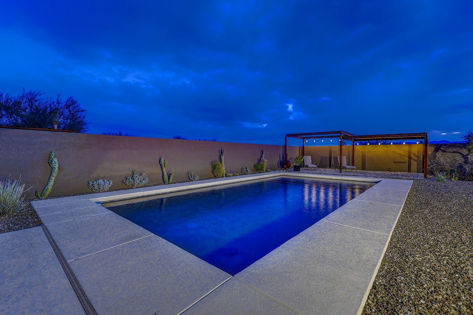 There is a large swimming pool in the backyard of a house.