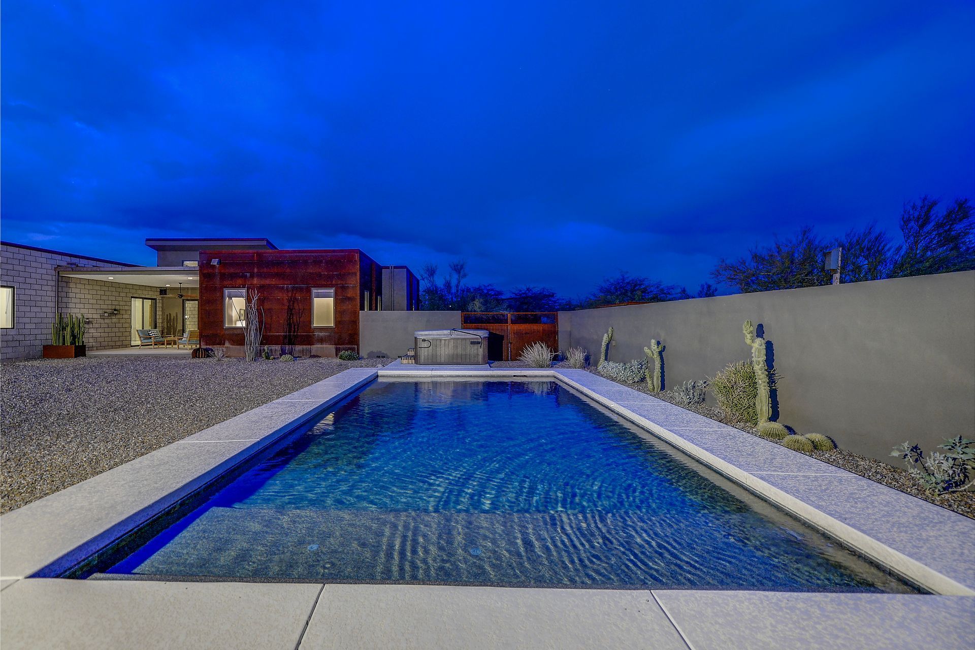 There is a large swimming pool in the backyard of a house.