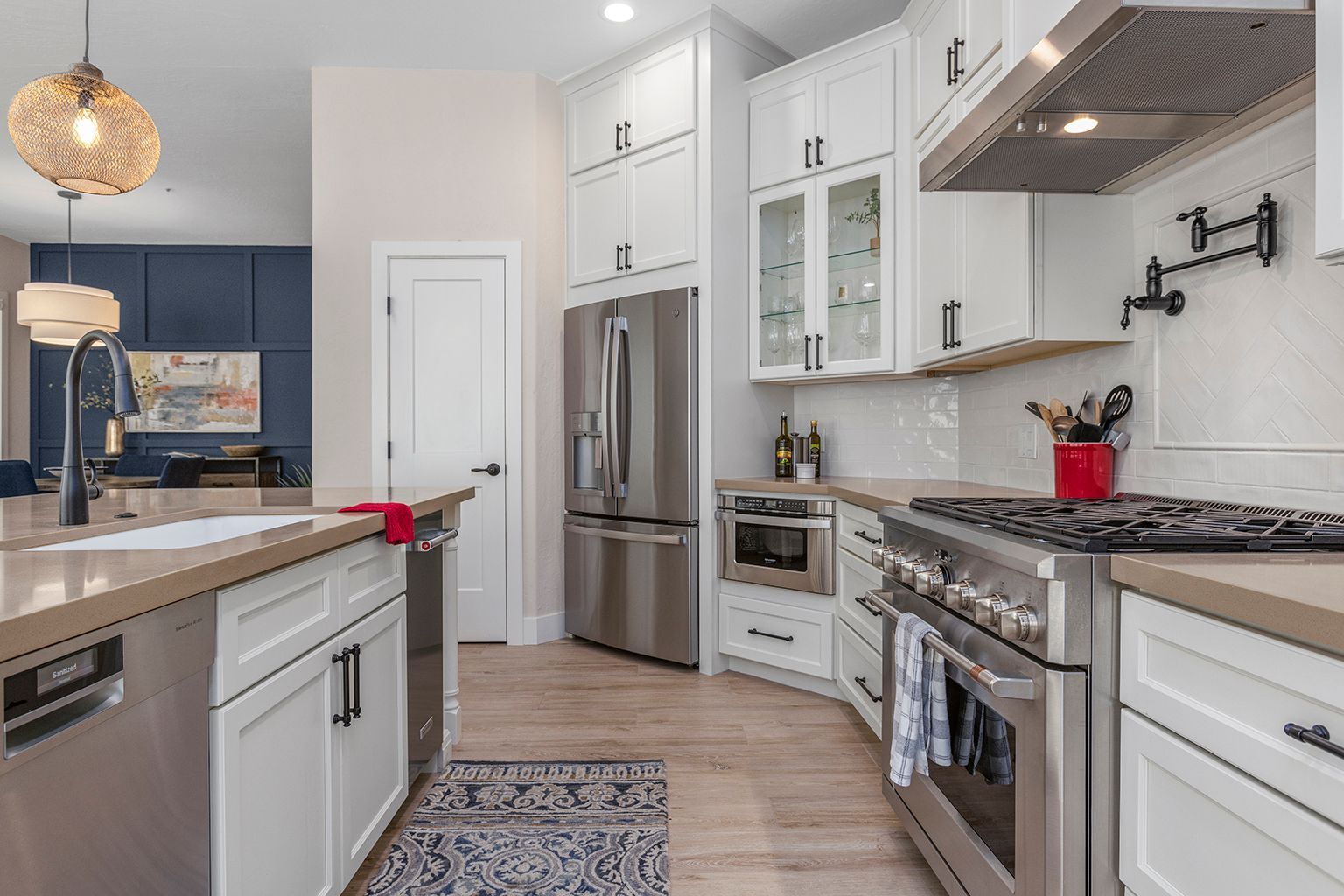 A kitchen with stainless steel appliances and white cabinets.