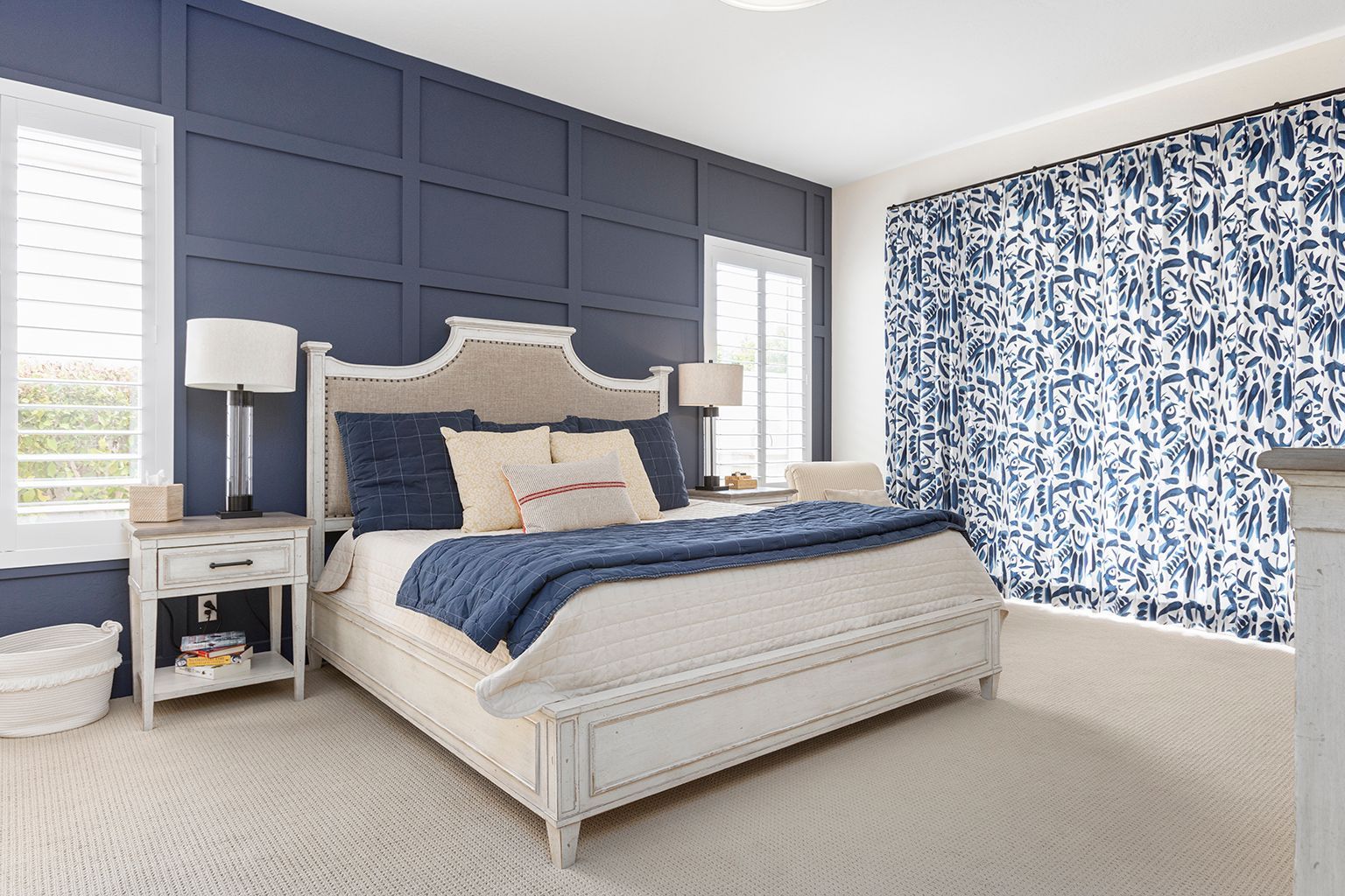 A bedroom with blue walls and a white bed.