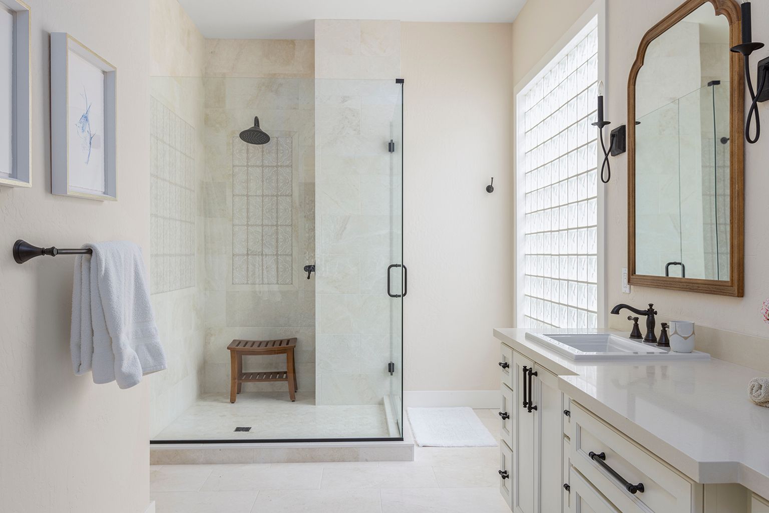 A bathroom with a walk in shower , sink and mirror.