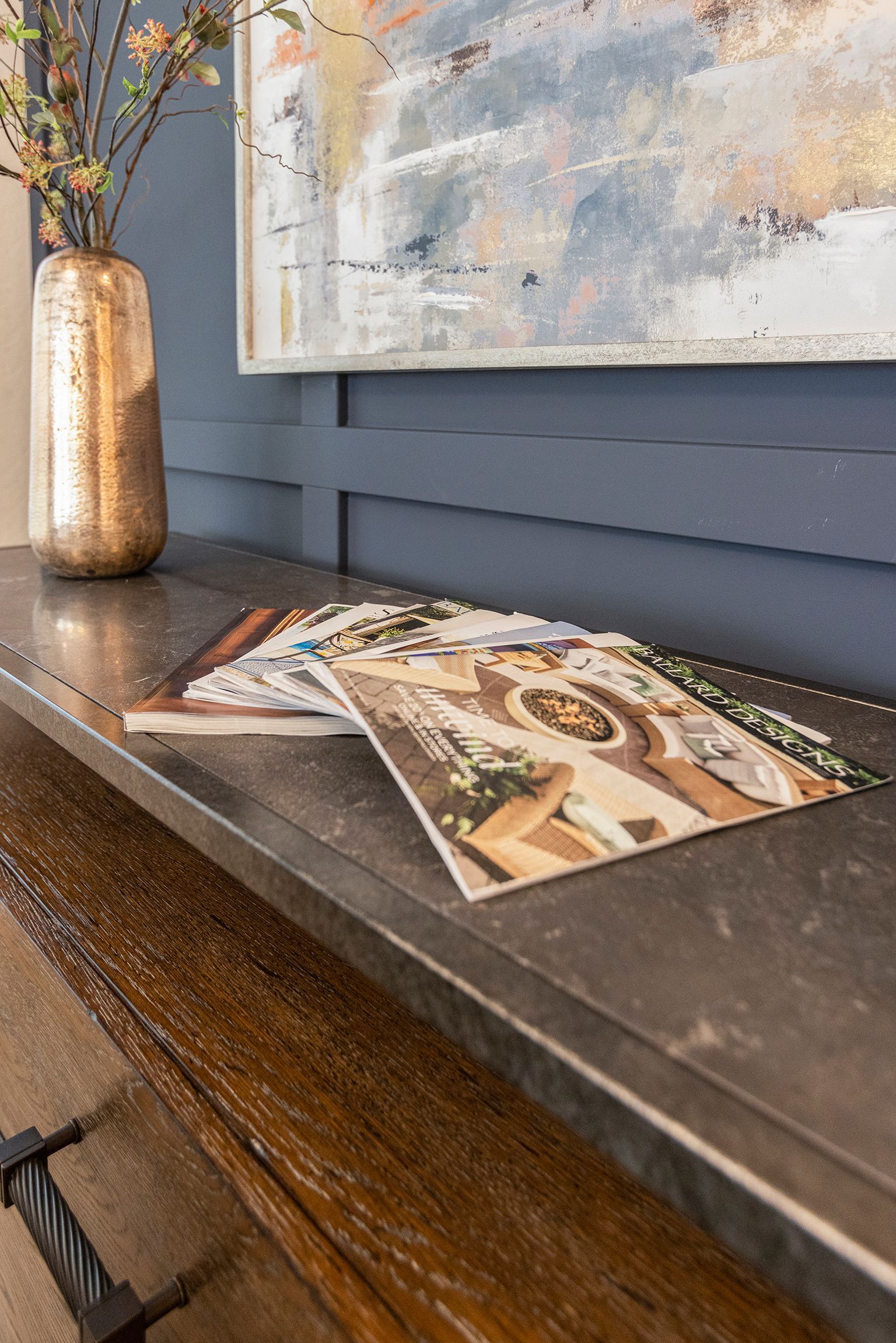 A stack of magazines sitting on top of a wooden table.
