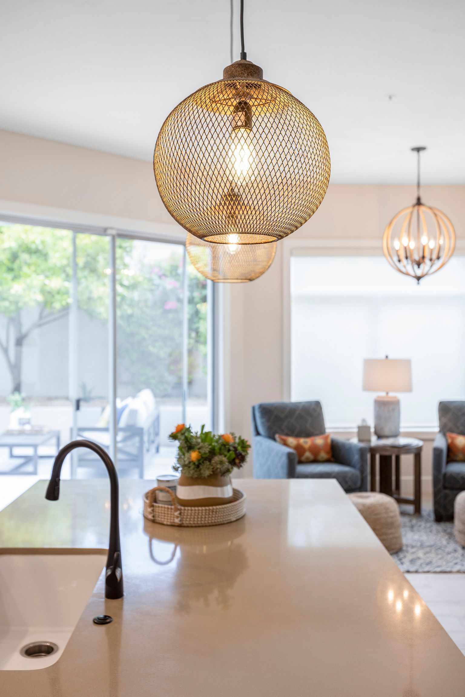 A kitchen with a sink and a light hanging from the ceiling
