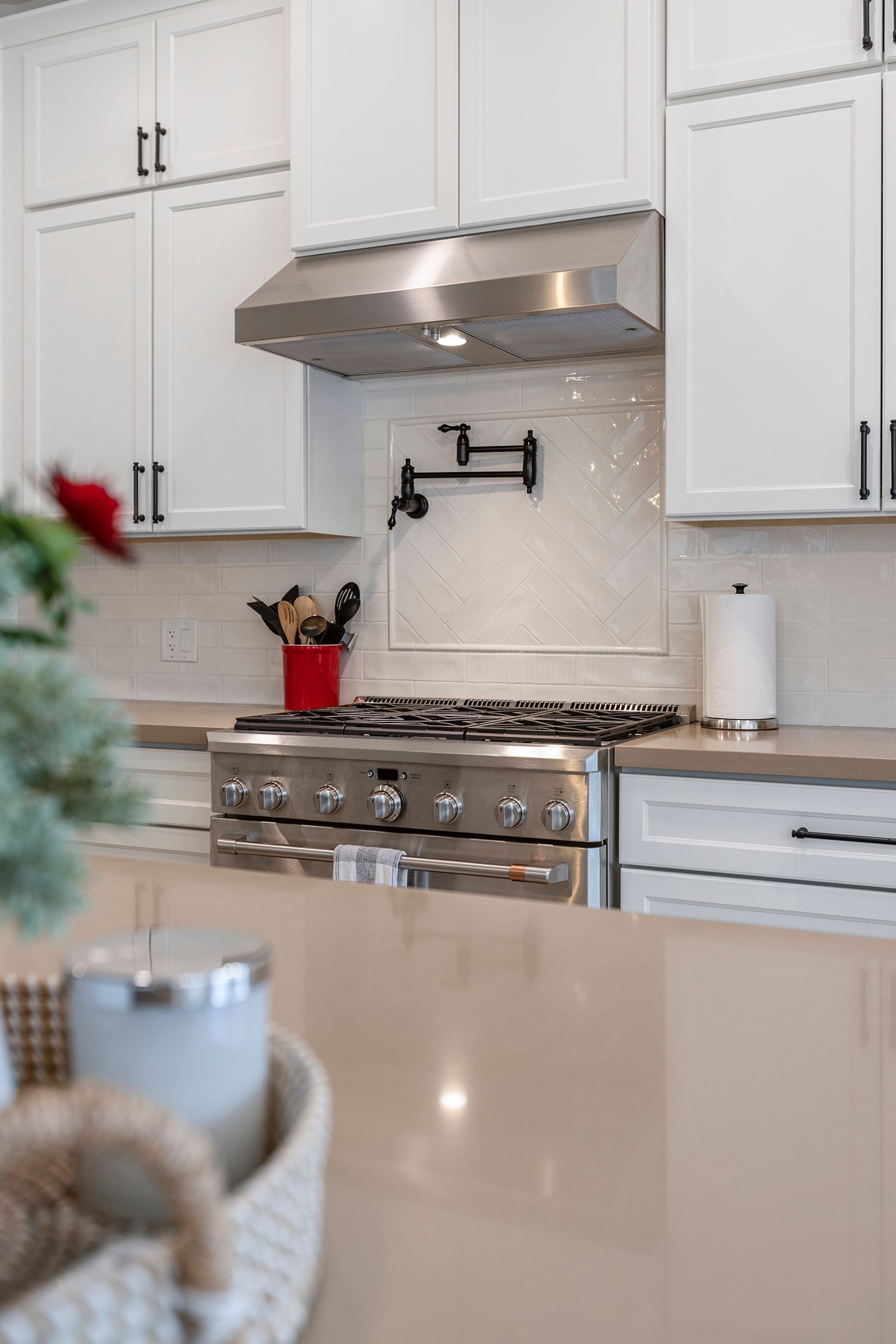 A kitchen with white cabinets and a stove top oven.