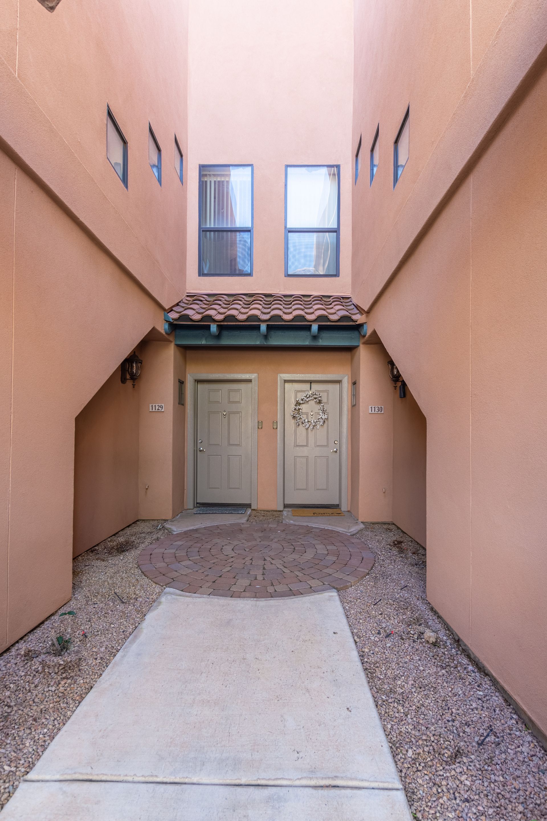 A narrow walkway leading to a building with two doors
