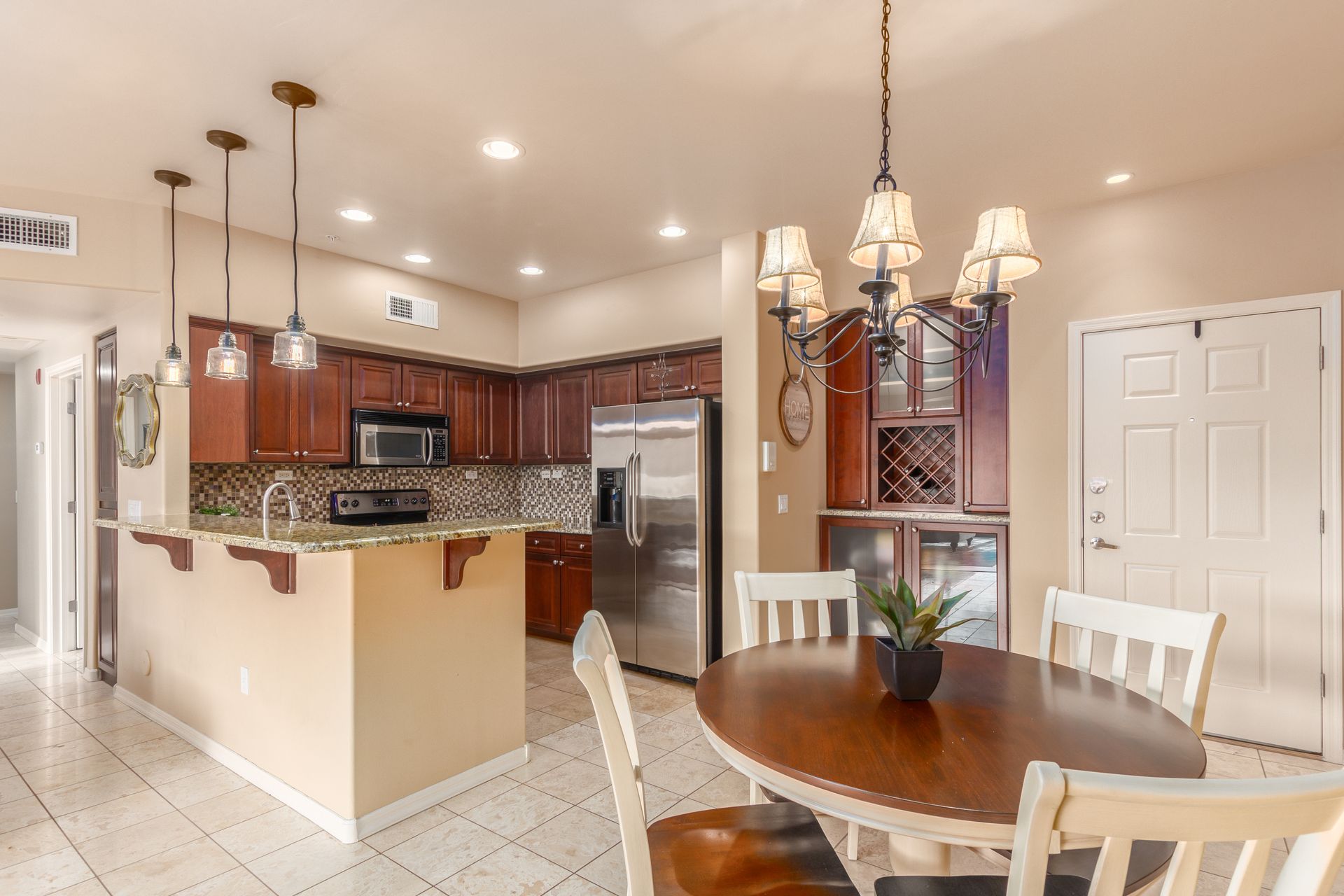 A kitchen with a table and chairs and a chandelier hanging from the ceiling.