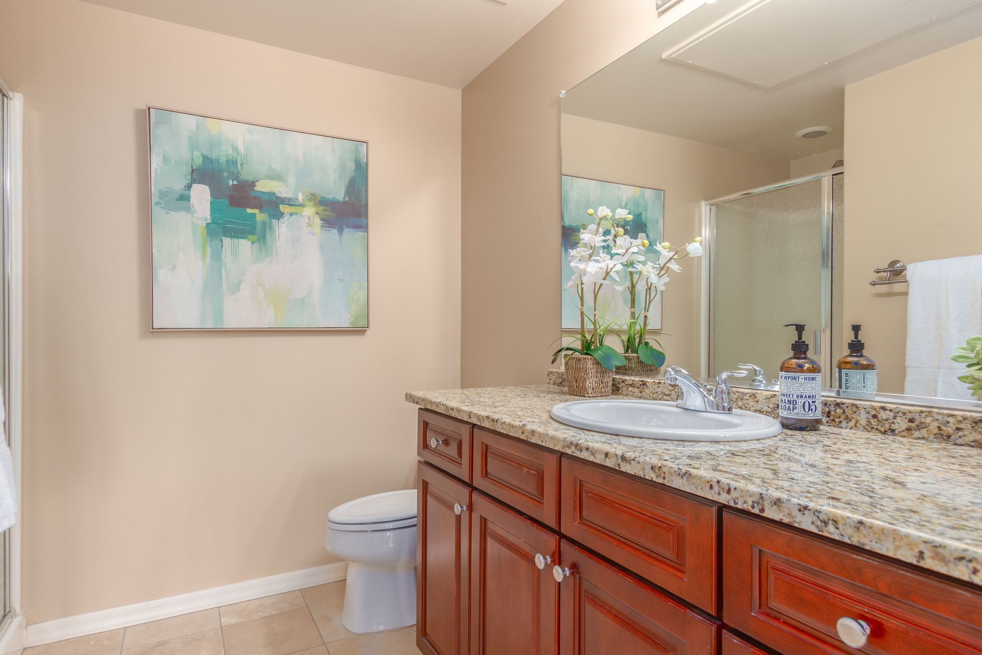 A bathroom with a sink , toilet , and mirror.