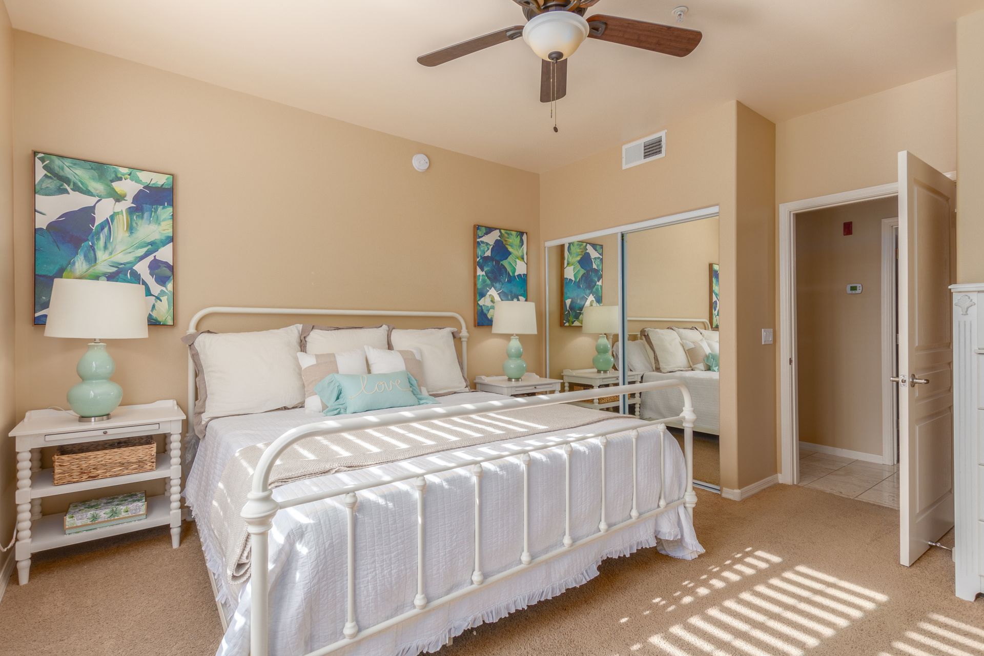 A bedroom with a large bed and a ceiling fan.