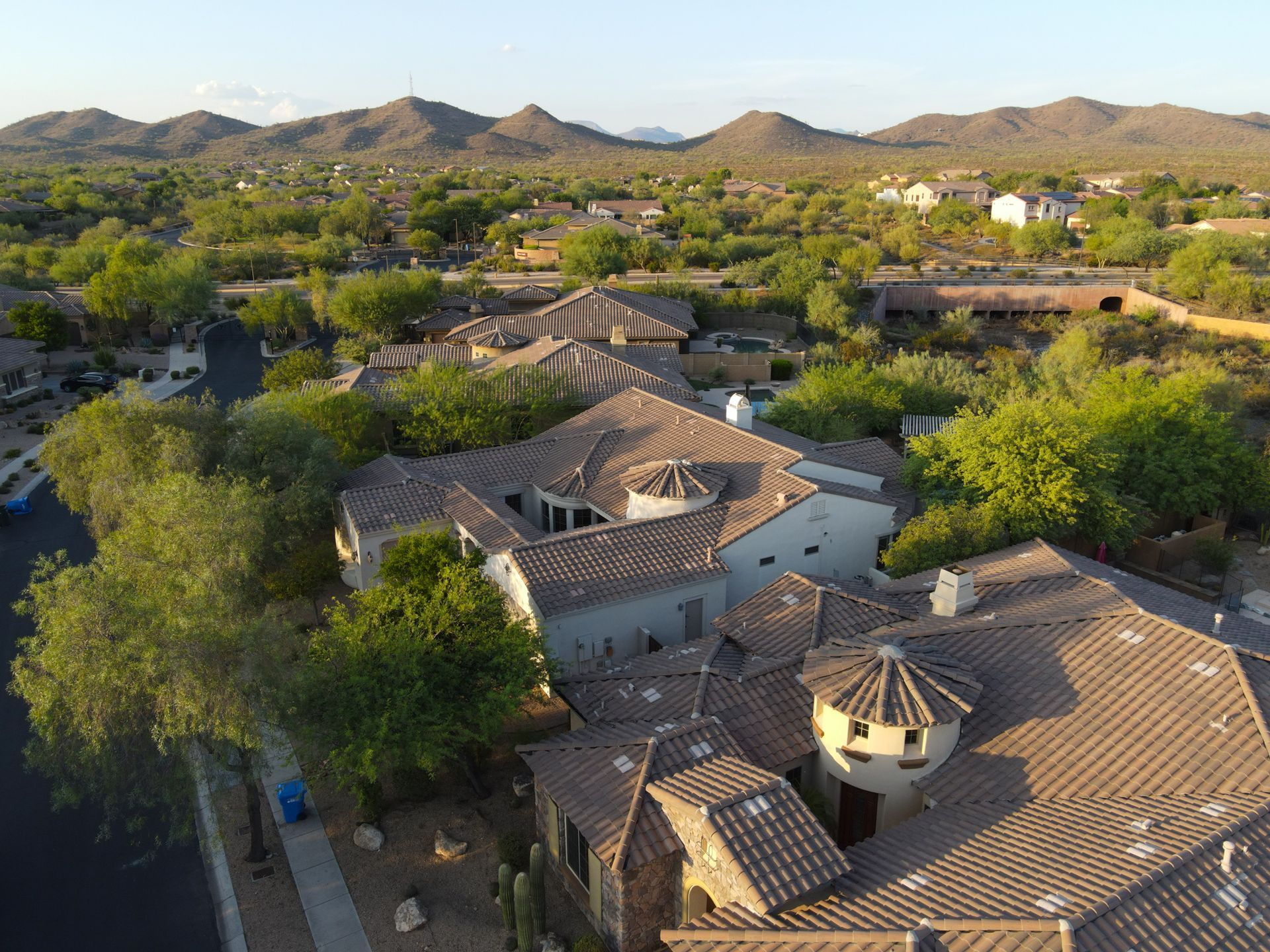An aerial view of a large house with mountains in the background