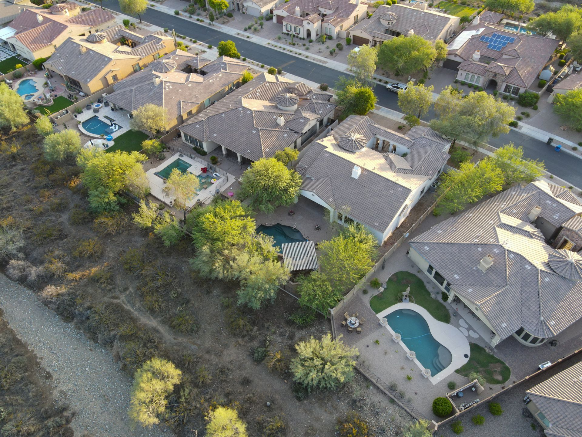 An aerial view of a residential area with houses and pools