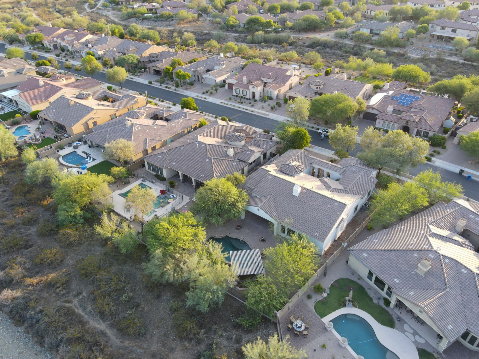 An aerial view of a residential area with lots of houses and a pool.