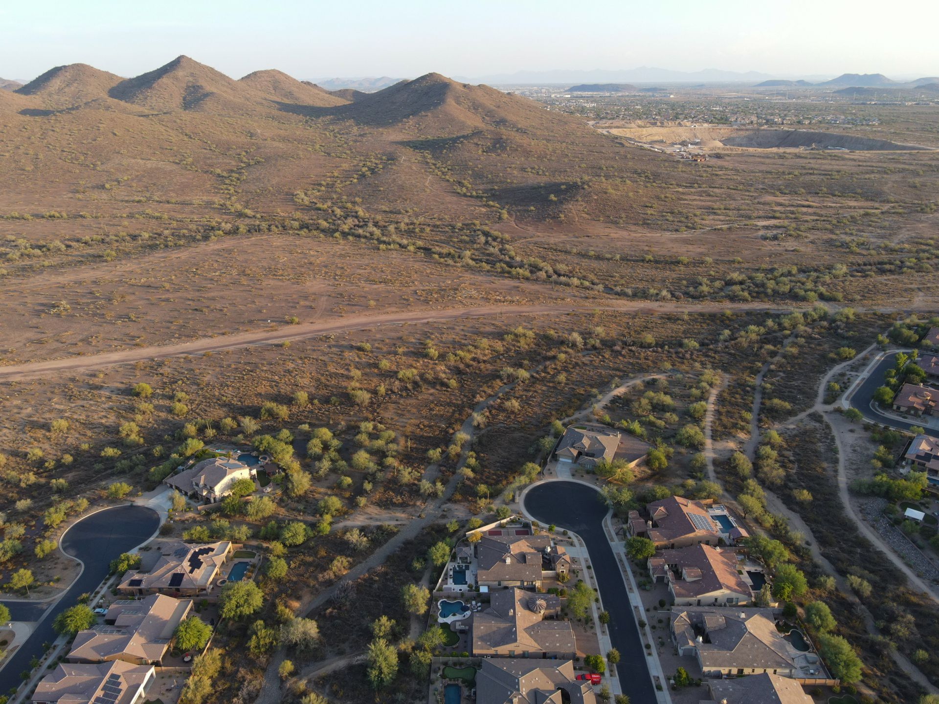 An aerial view of a residential area with mountains in the background.