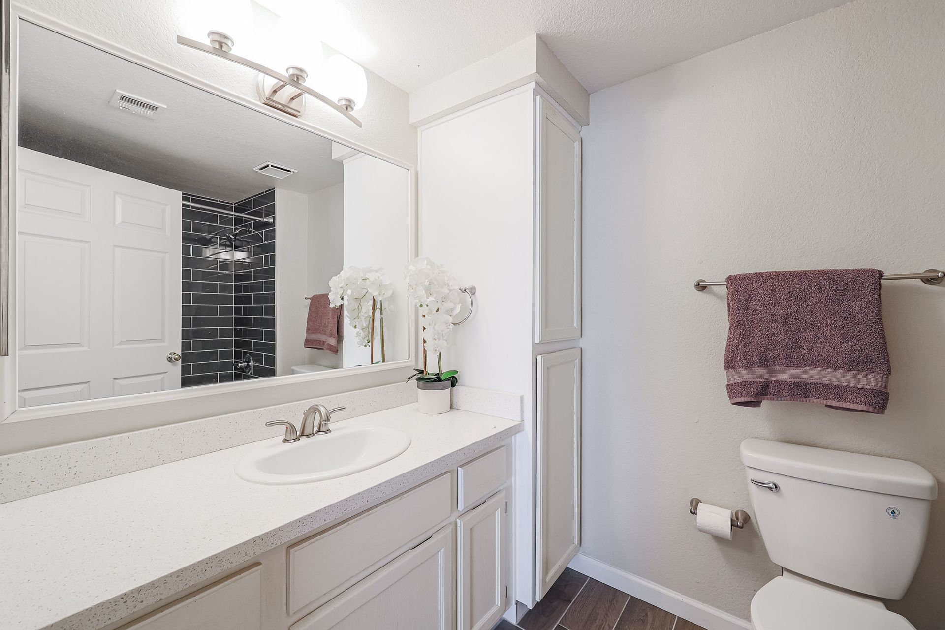 A bathroom with a sink , toilet and mirror.