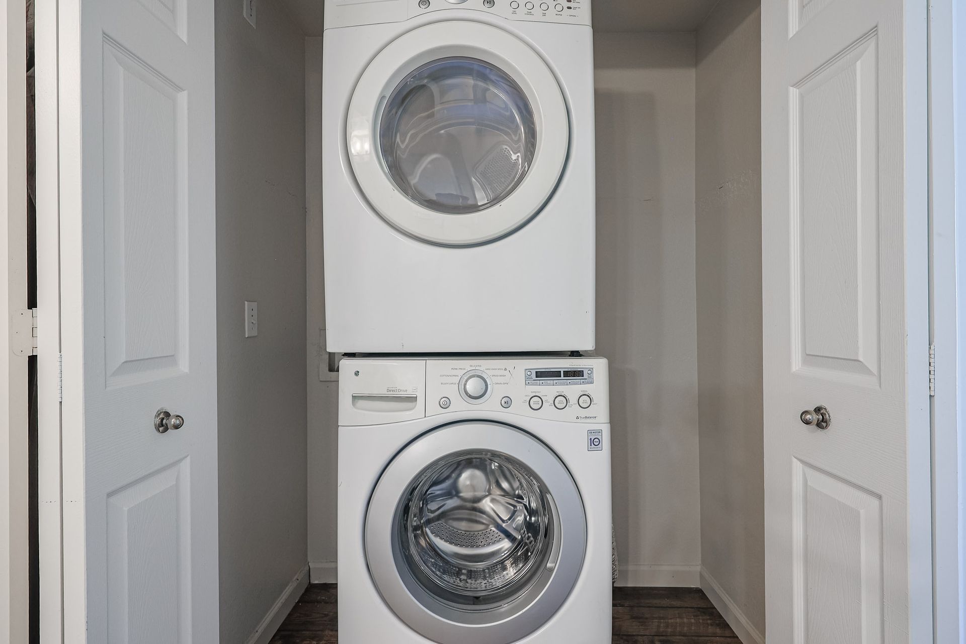 A washer and dryer are stacked on top of each other in a laundry room.