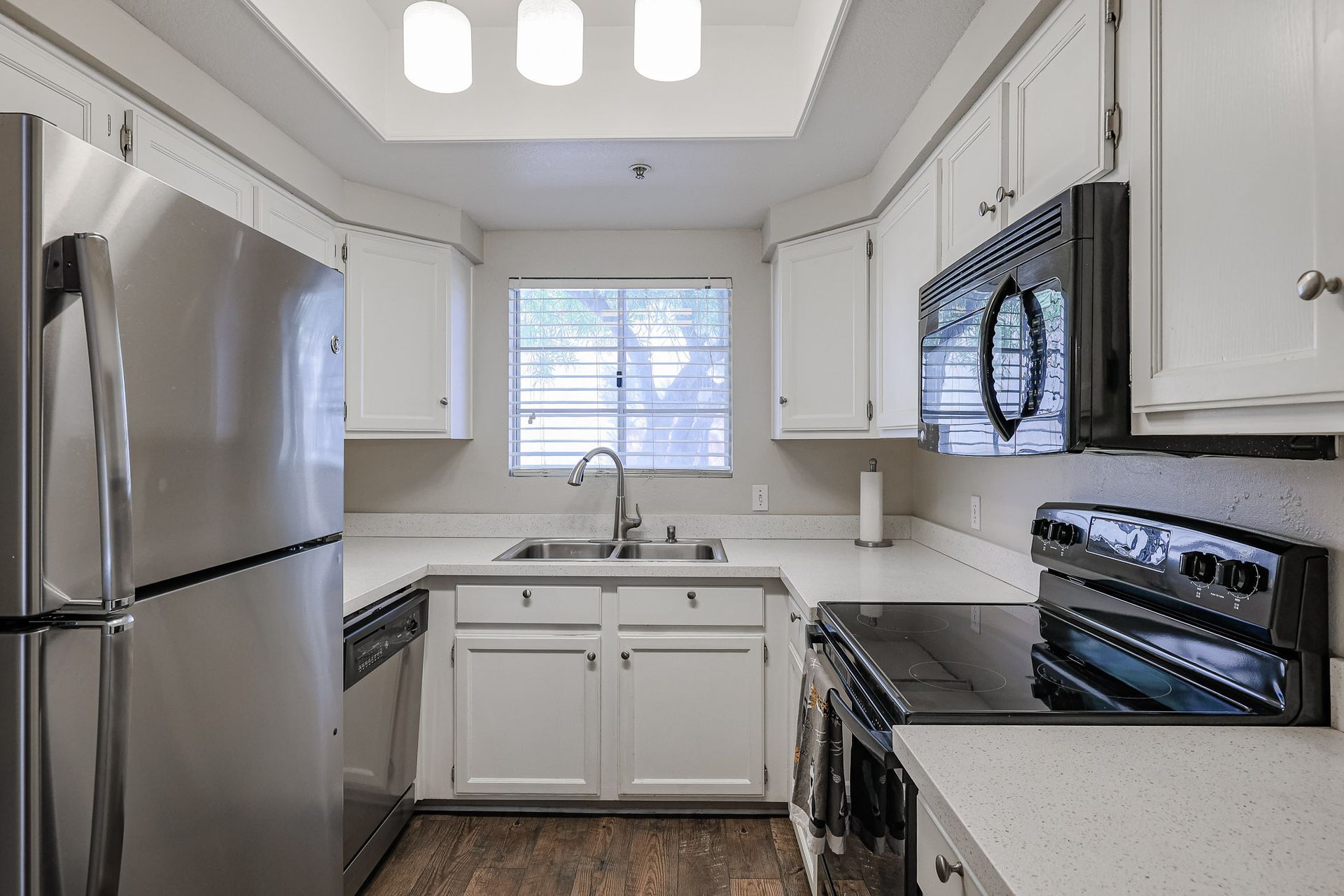 A kitchen with stainless steel appliances and white cabinets.