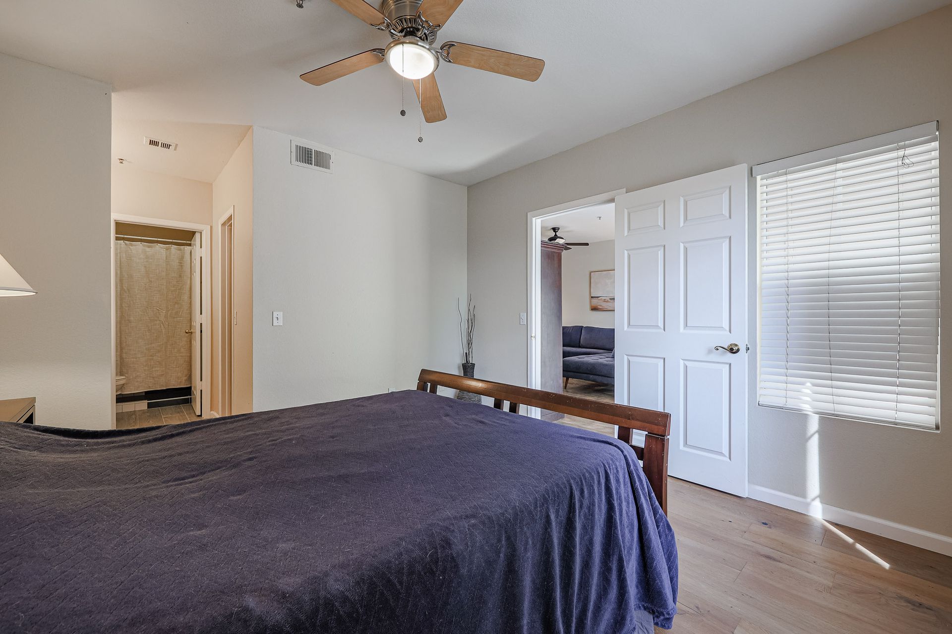 A bedroom with a bed and a ceiling fan