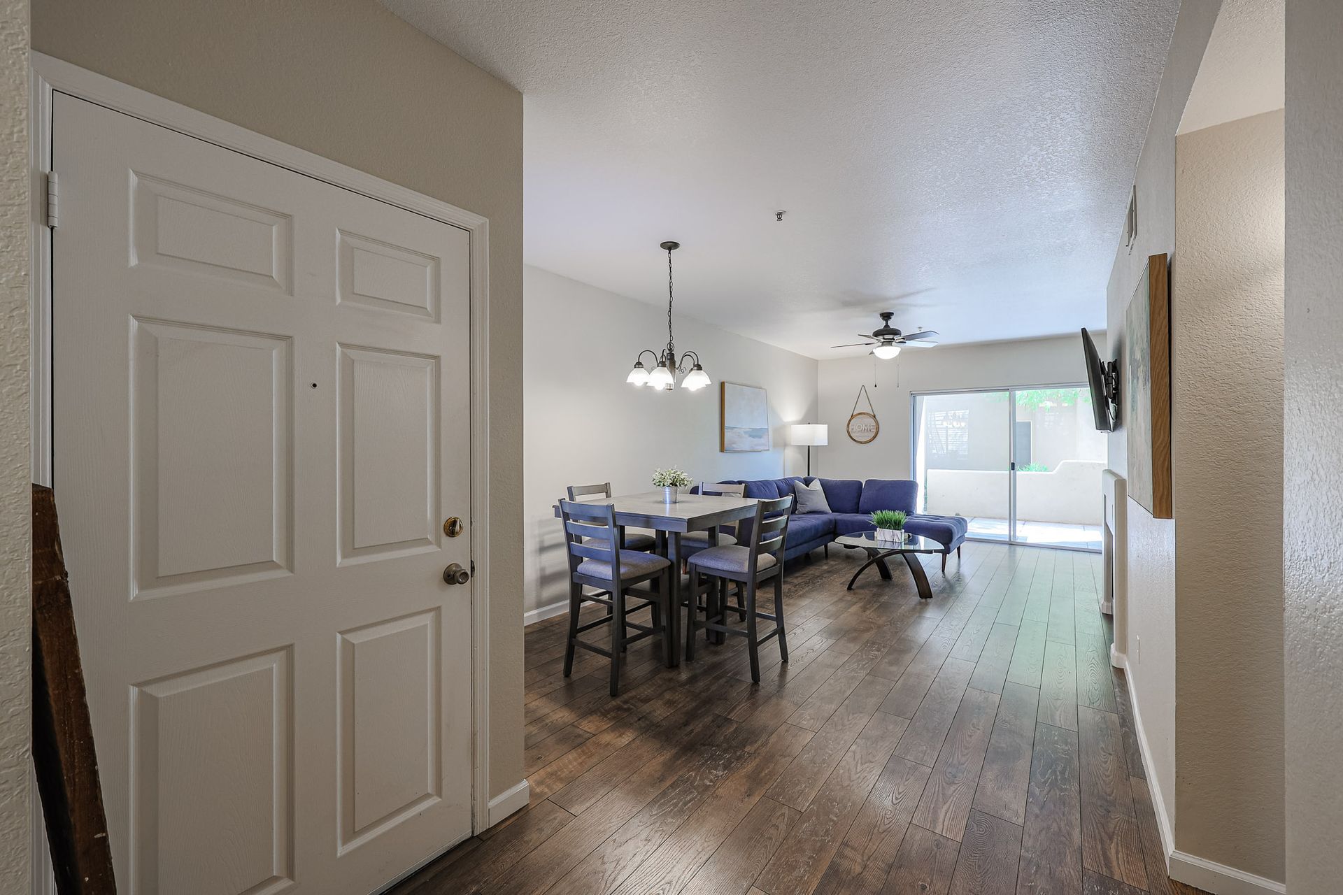 A living room with hardwood floors and a dining table and chairs.
