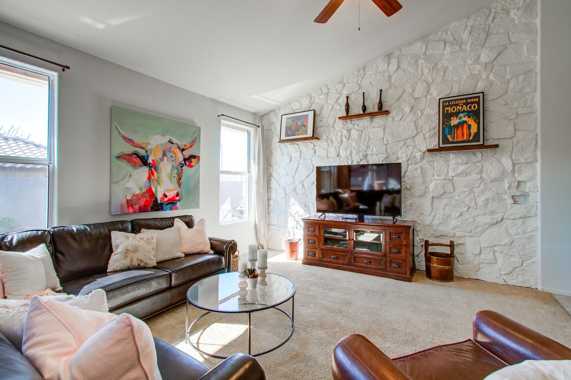 A living room with a couch , chair , coffee table and television.