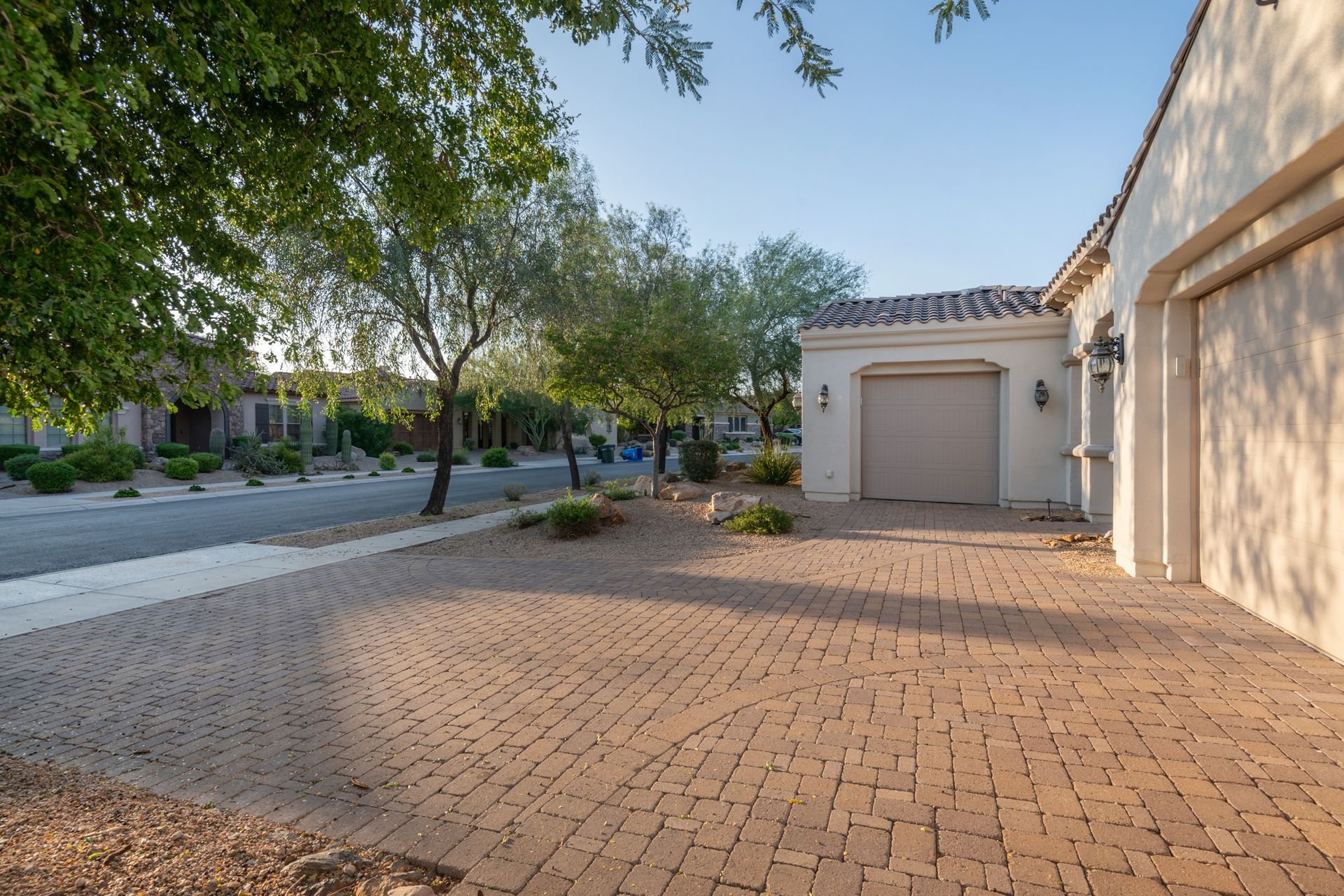A garage with a brick driveway in front of it