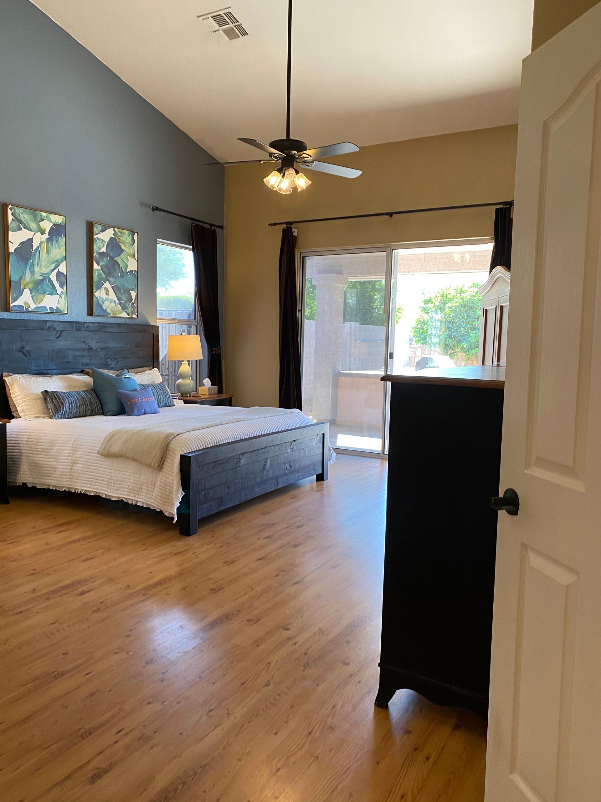 A bedroom with a large bed and a ceiling fan