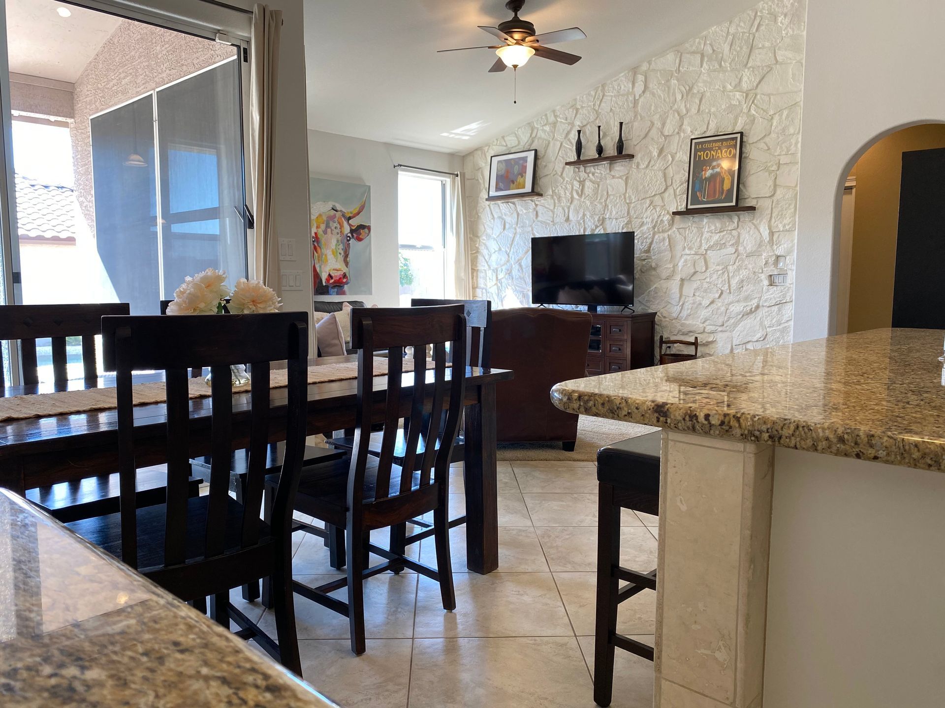A dining room with a table and chairs and a ceiling fan
