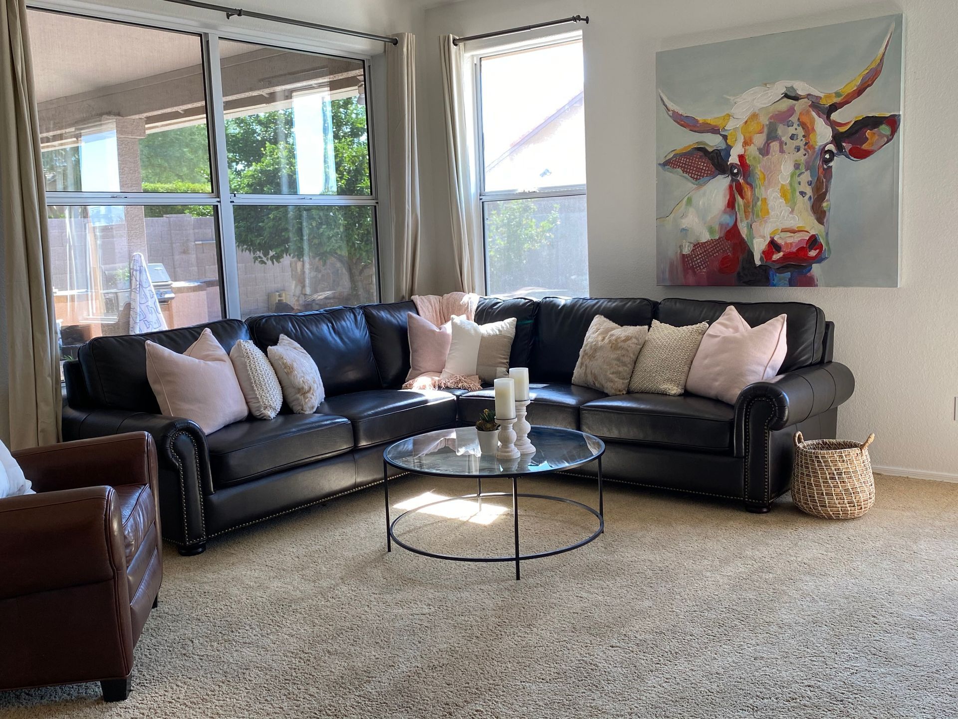 A living room filled with furniture and a painting of a cow on the wall.