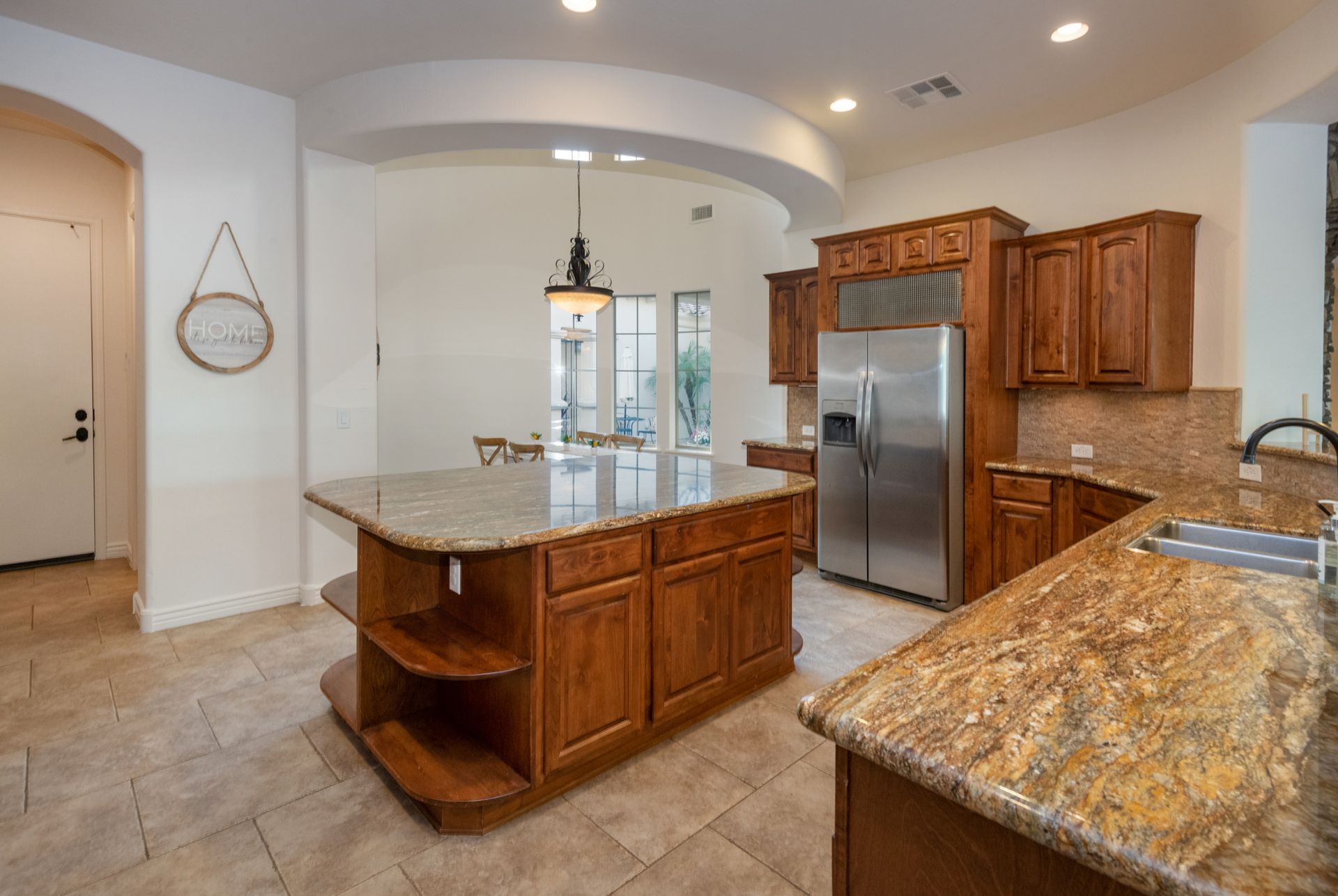 A kitchen with stainless steel appliances , granite counter tops , and wooden cabinets.