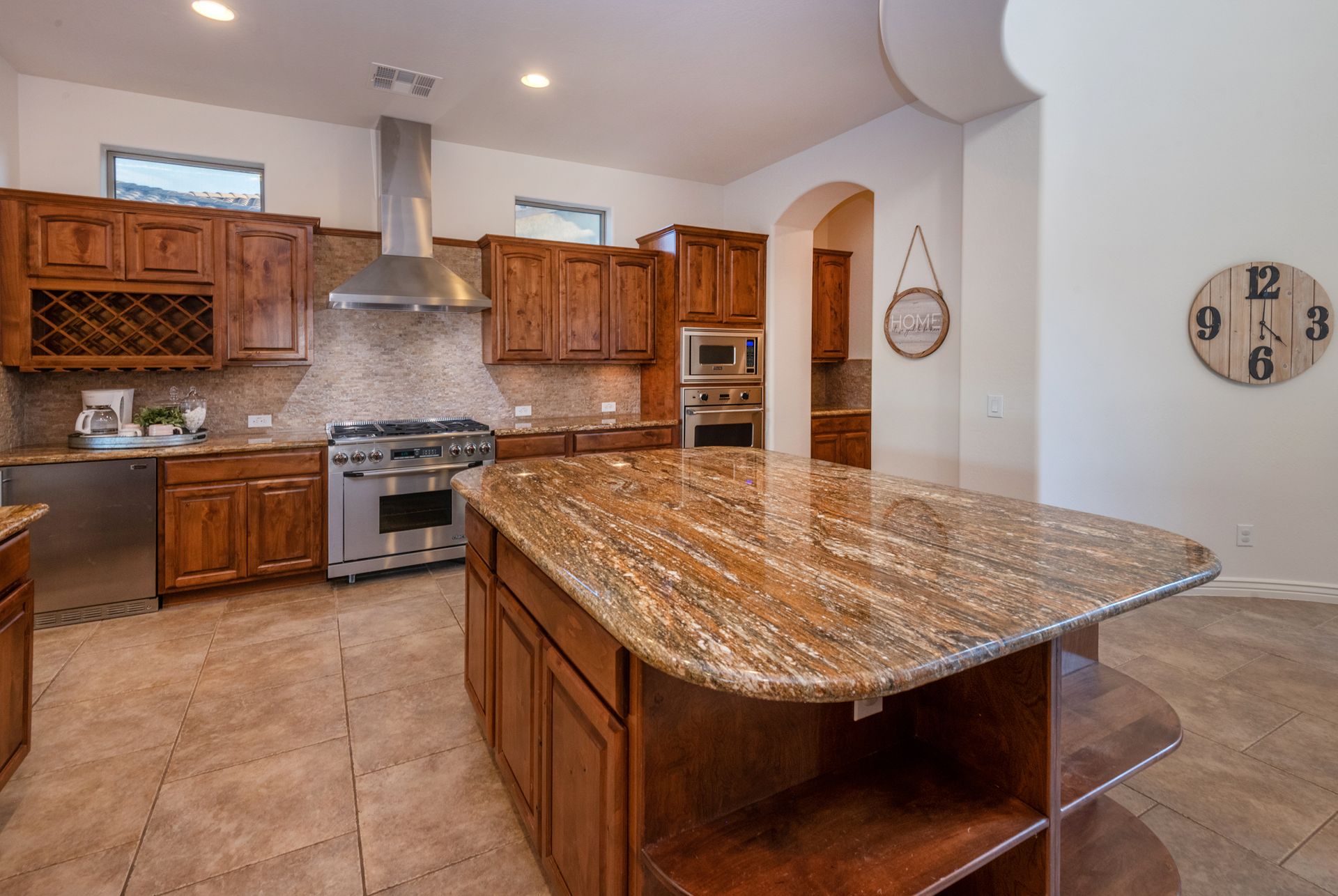 A kitchen with a large island and a clock on the wall.