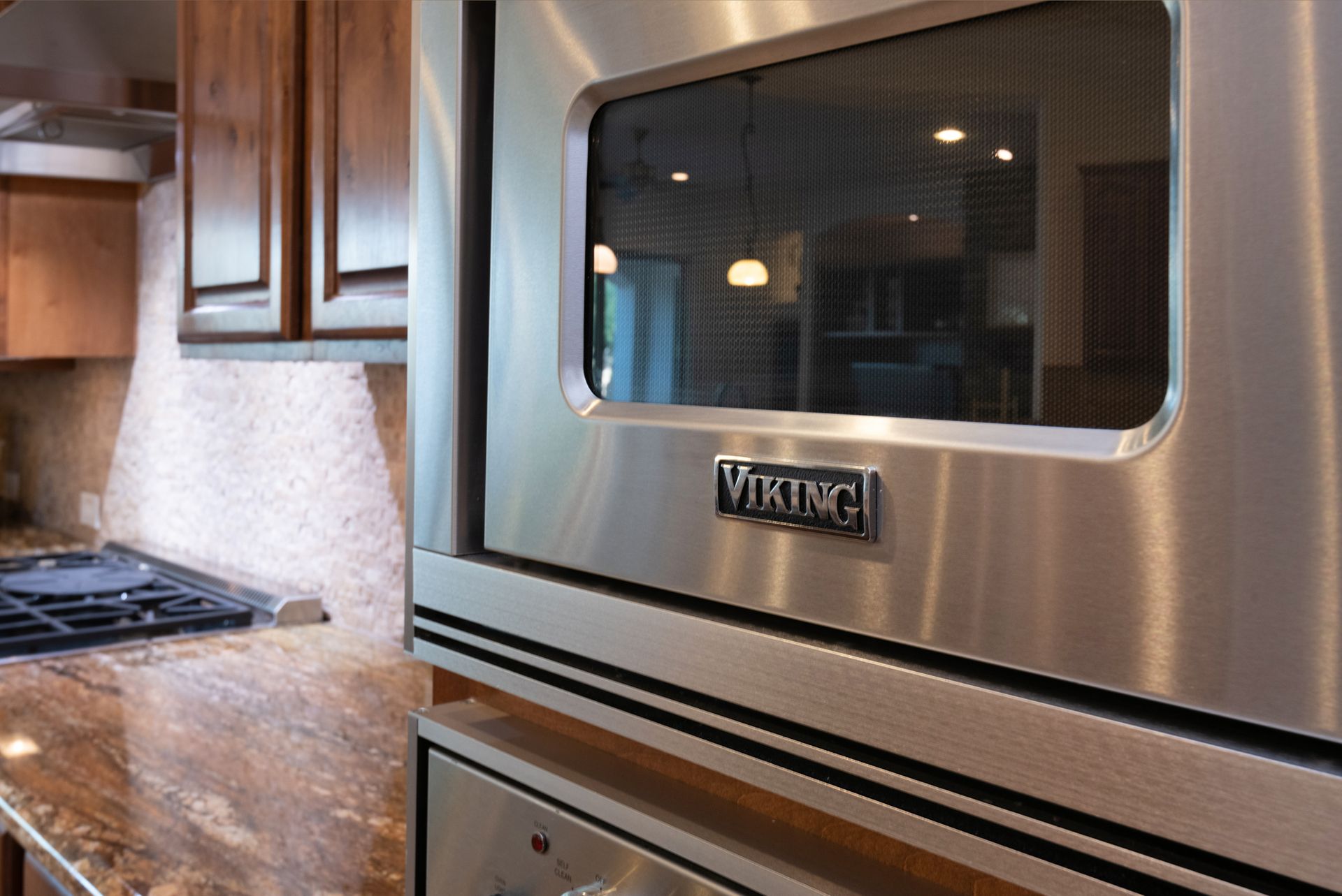 A stainless steel viking oven is sitting in a kitchen next to a stove.