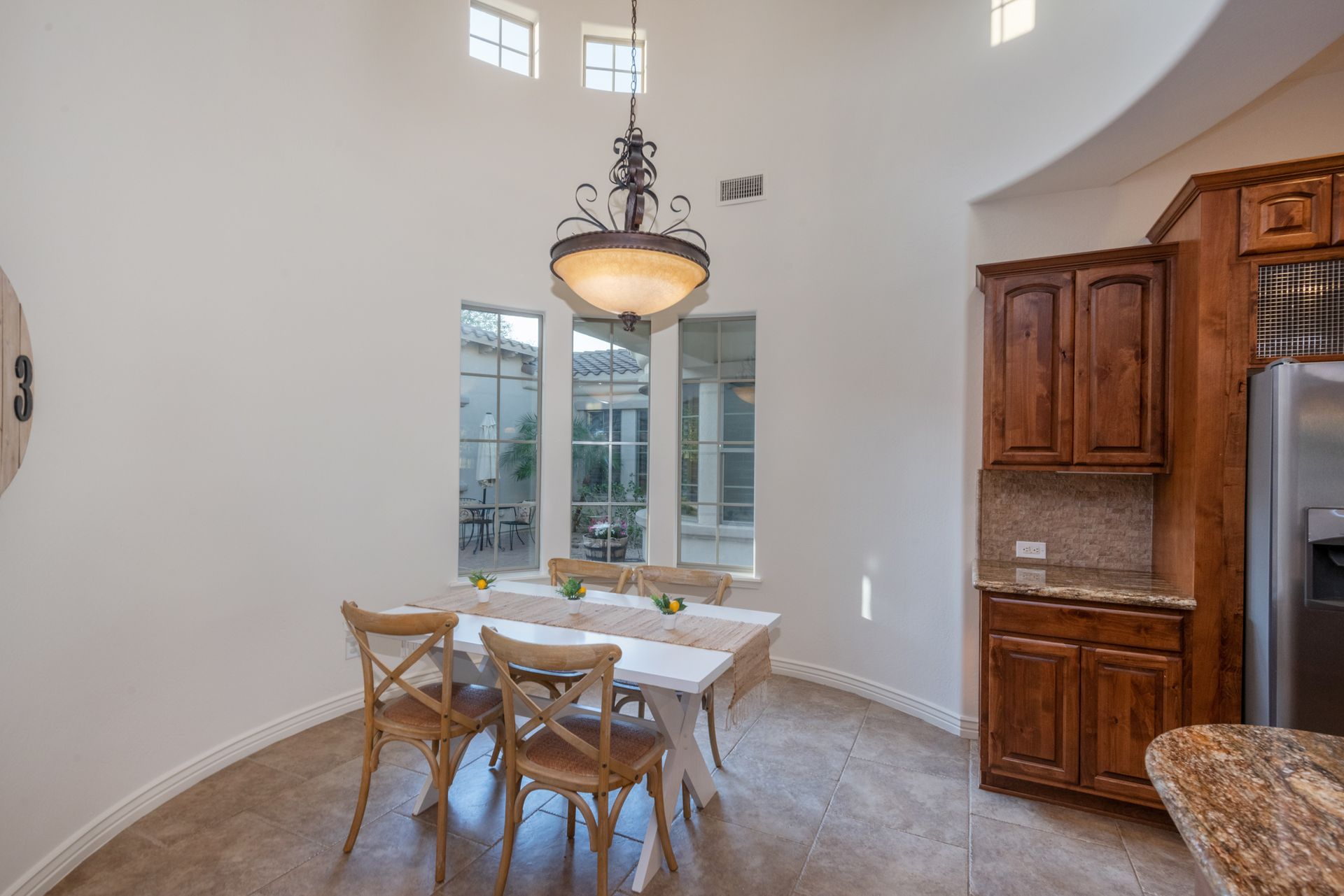 A dining room with a table and chairs and a chandelier hanging from the ceiling.