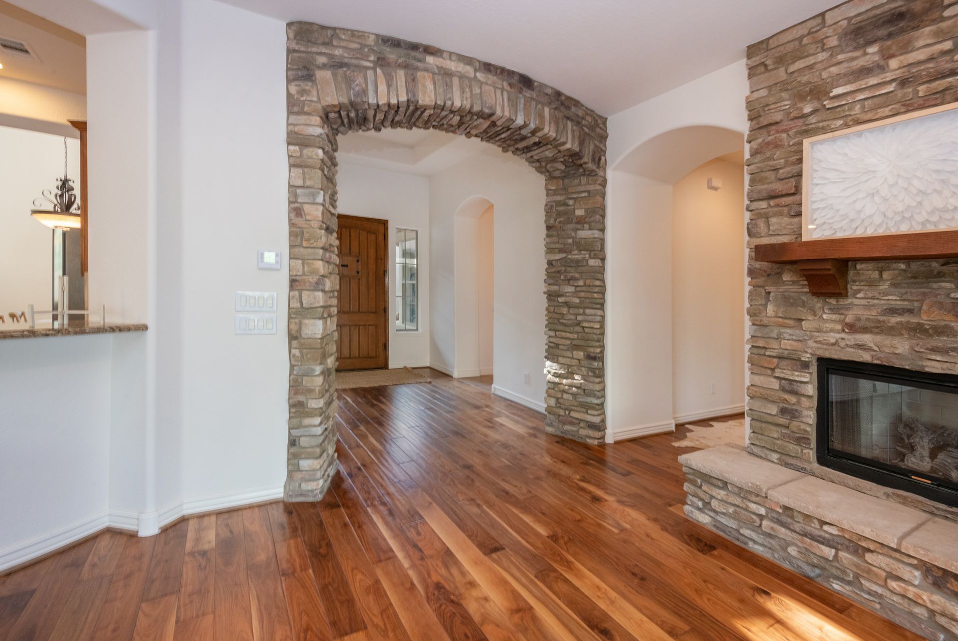 A living room with hardwood floors and a fireplace.
