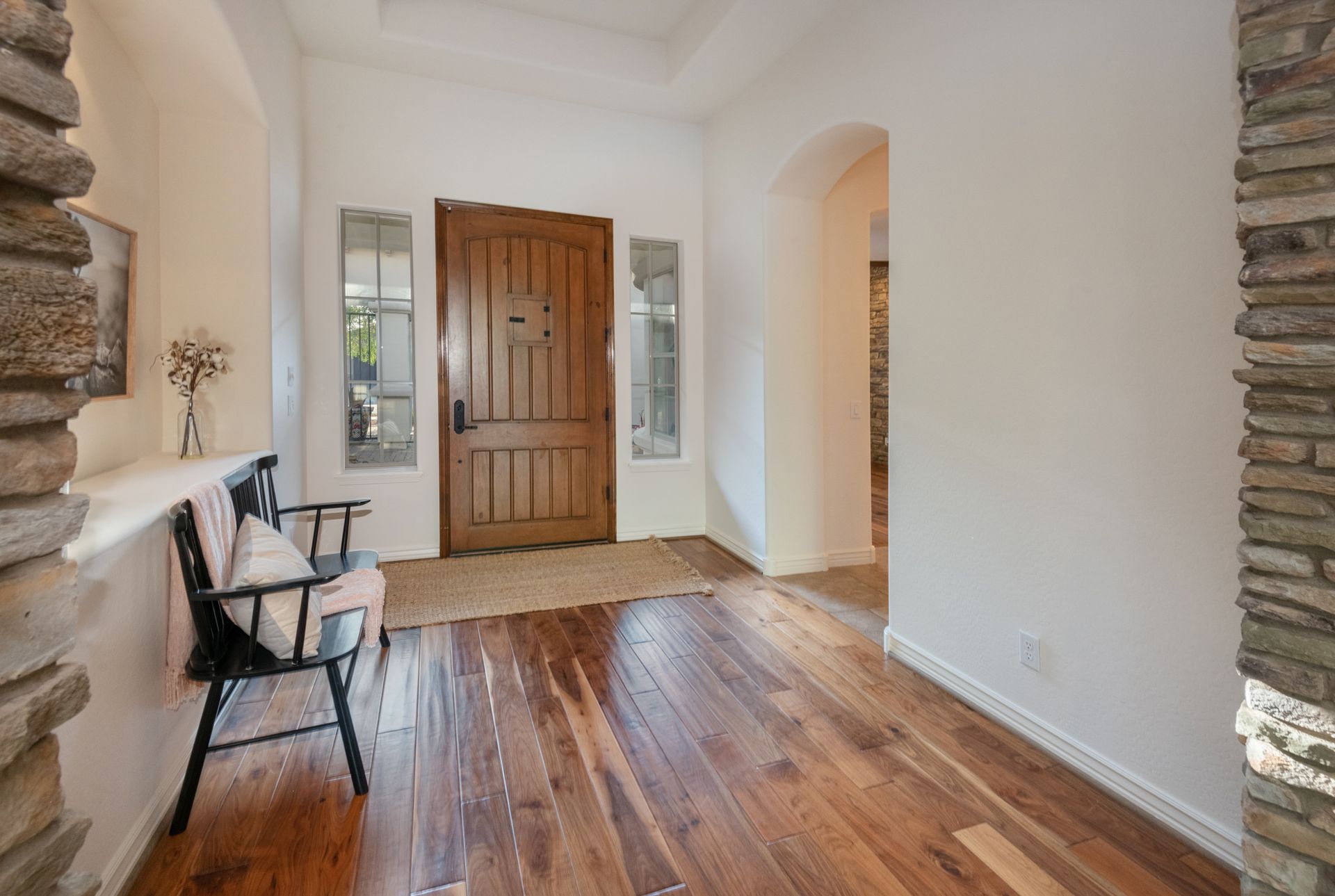 A hallway with hardwood floors and a wooden door.