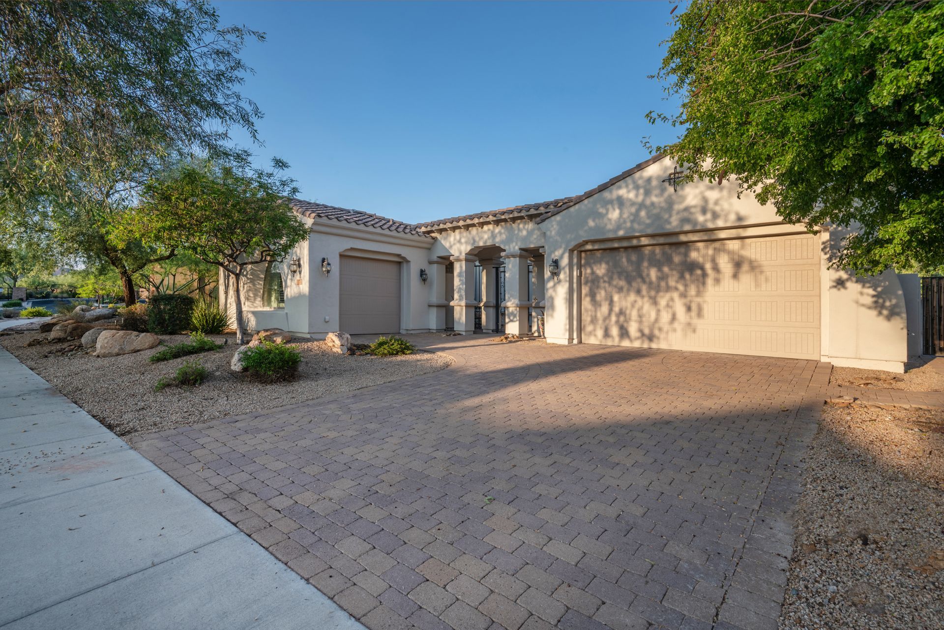 A house with a brick driveway and two garages