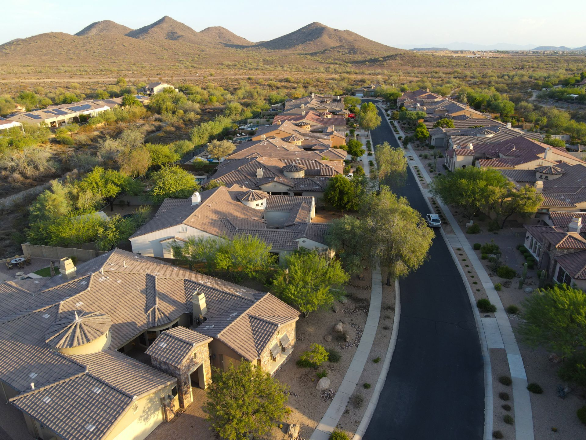 An aerial view of a residential area with mountains in the background.