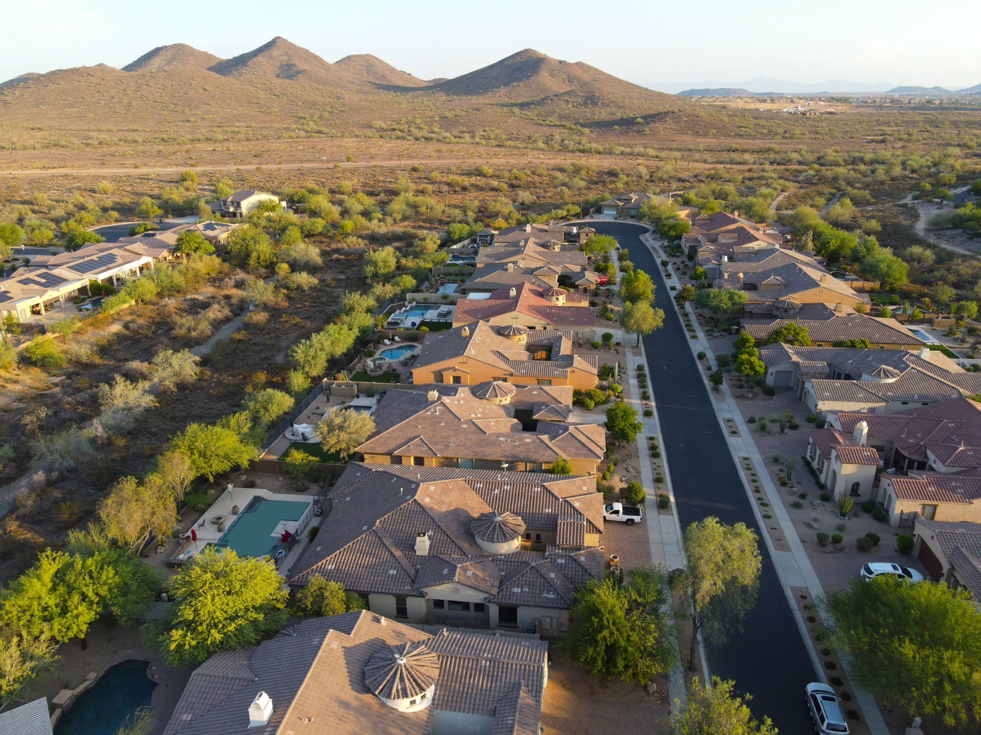 An aerial view of a residential area with mountains in the background.