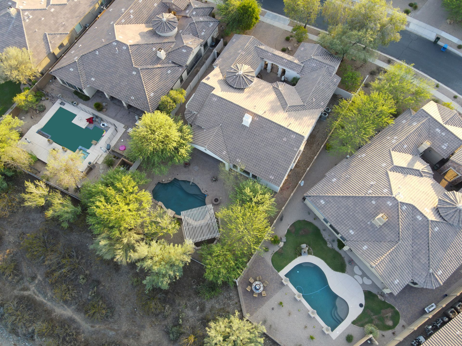 An aerial view of a residential area with houses and pools