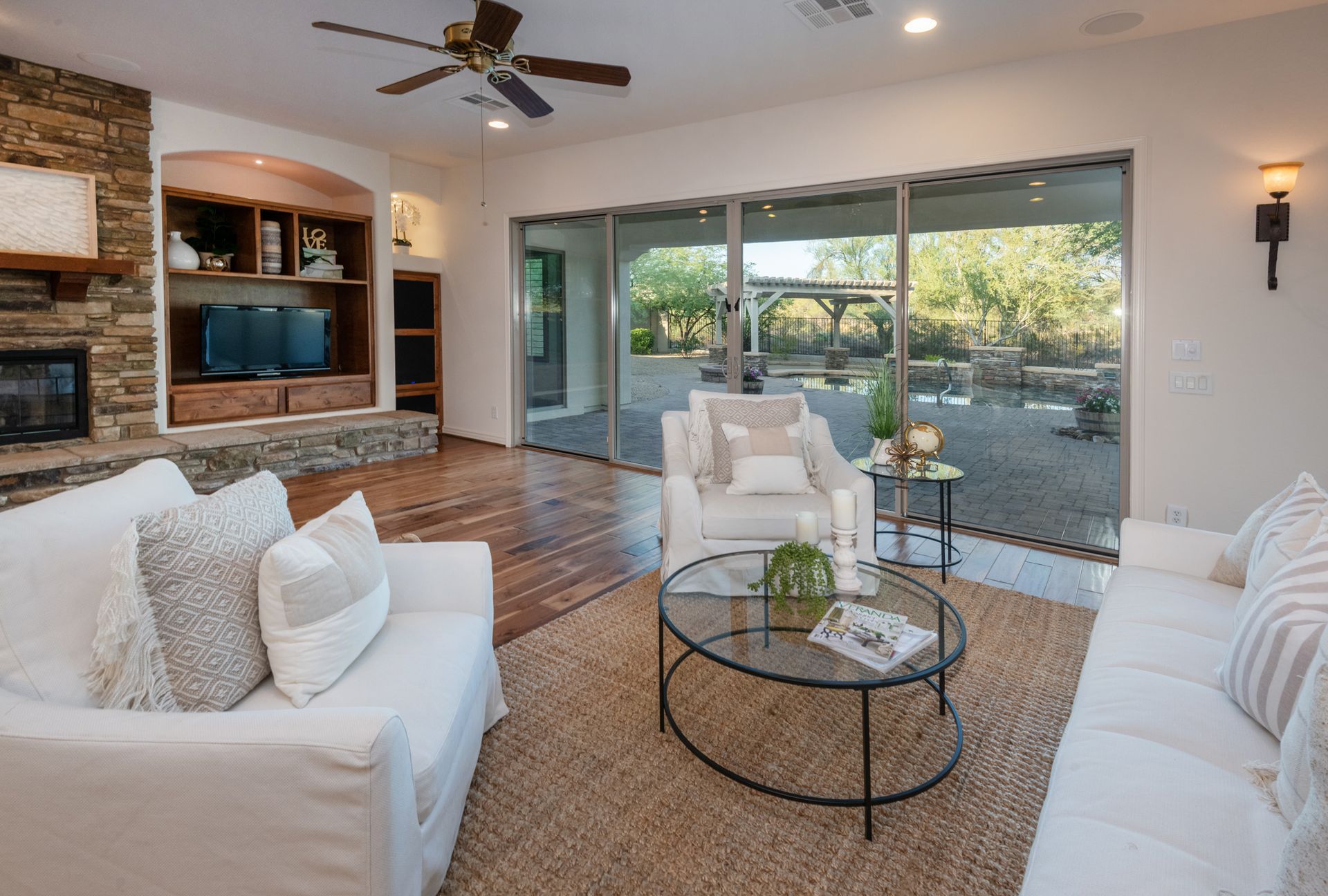 A living room with a couch , chair , coffee table and television.
