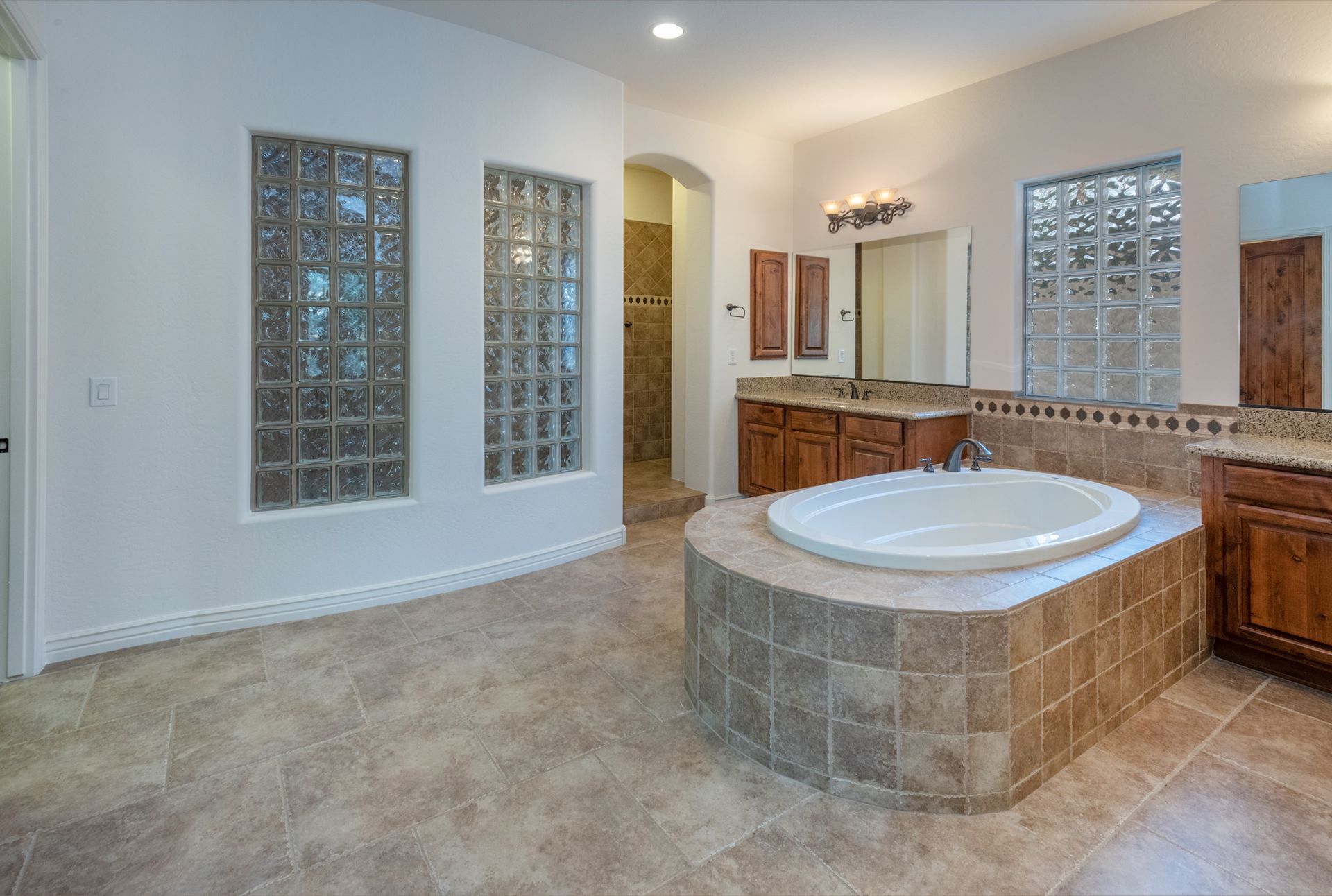 A bathroom with a large tub and two sinks.