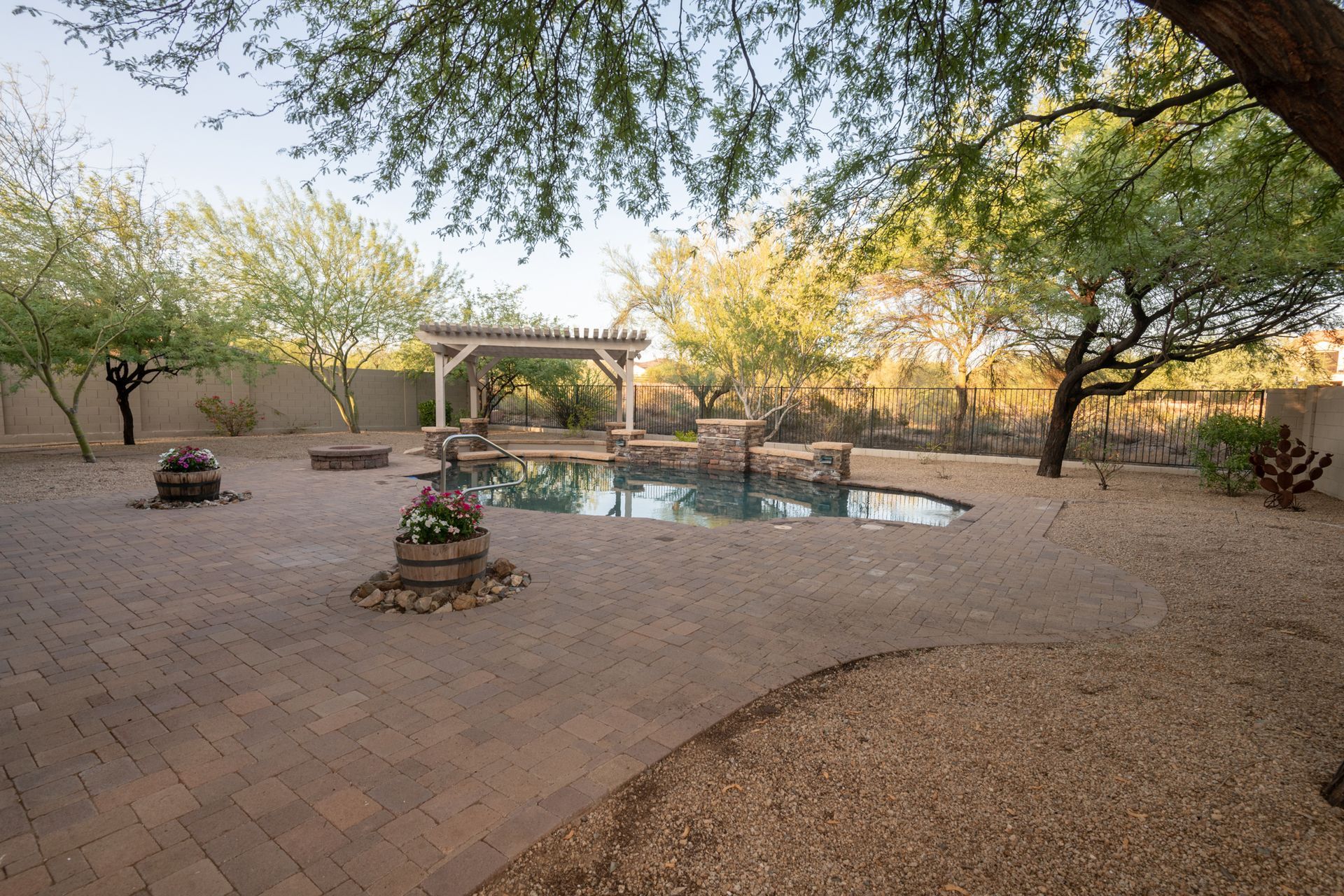 A large backyard with a swimming pool and a pergola.