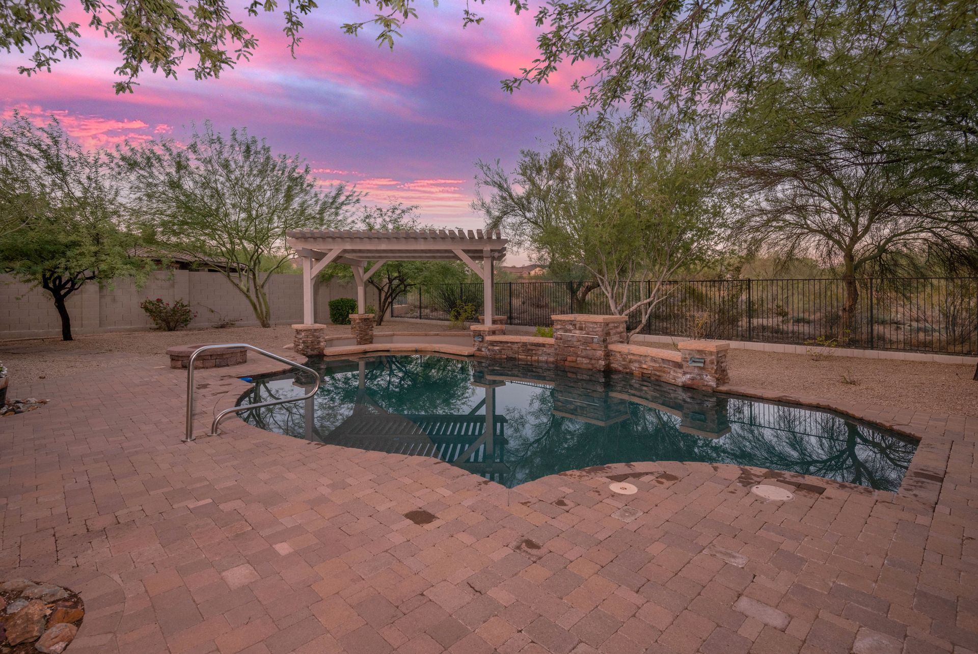 There is a large swimming pool in the backyard of a house.