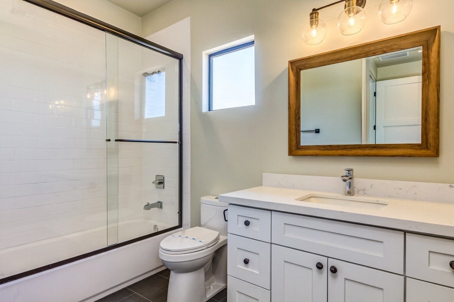 A bathroom with a toilet , sink , and mirror.