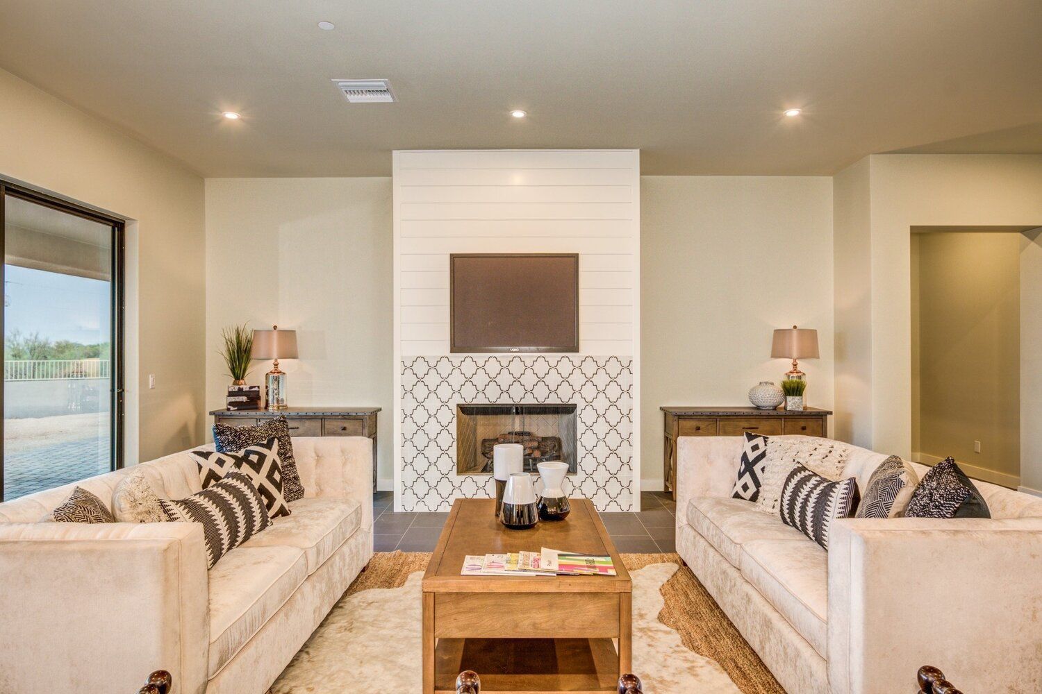 A living room with two couches , a coffee table , and a fireplace.