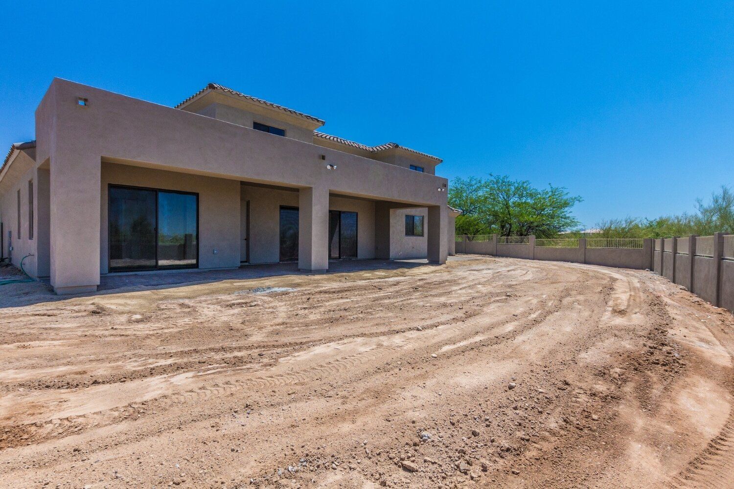 A large house is sitting on top of a dirt hill.