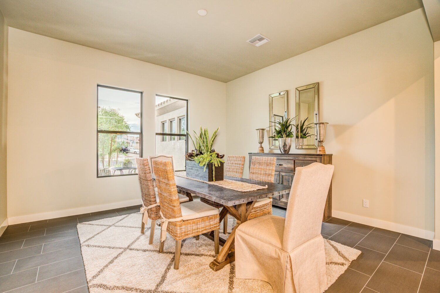 A dining room with a table and chairs and a rug.