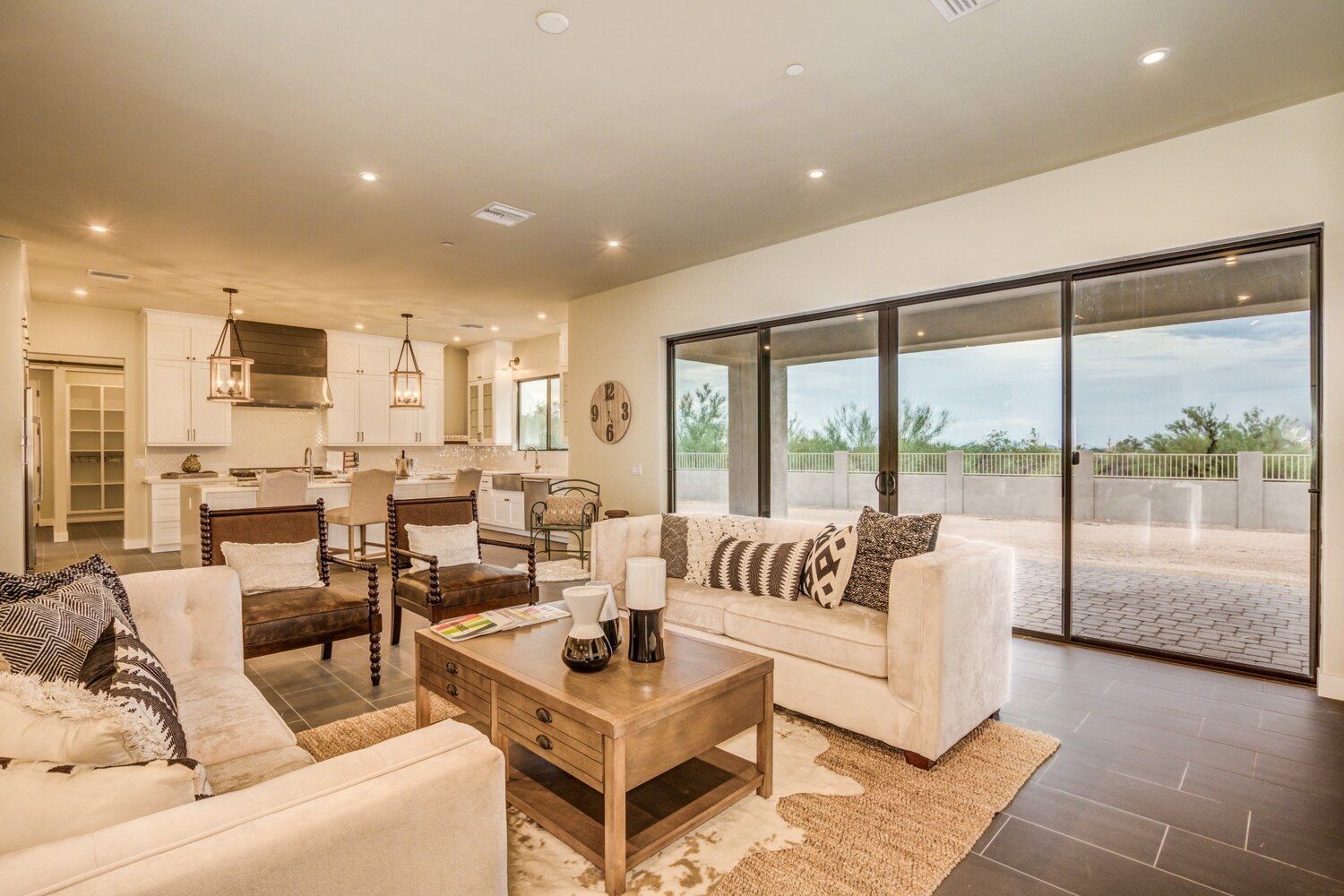 A living room with a couch , chair , coffee table and sliding glass doors.