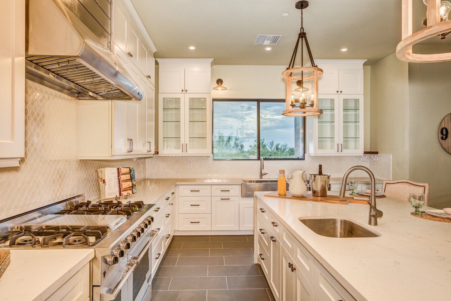 A kitchen with white cabinets , stainless steel appliances , a sink and a stove.