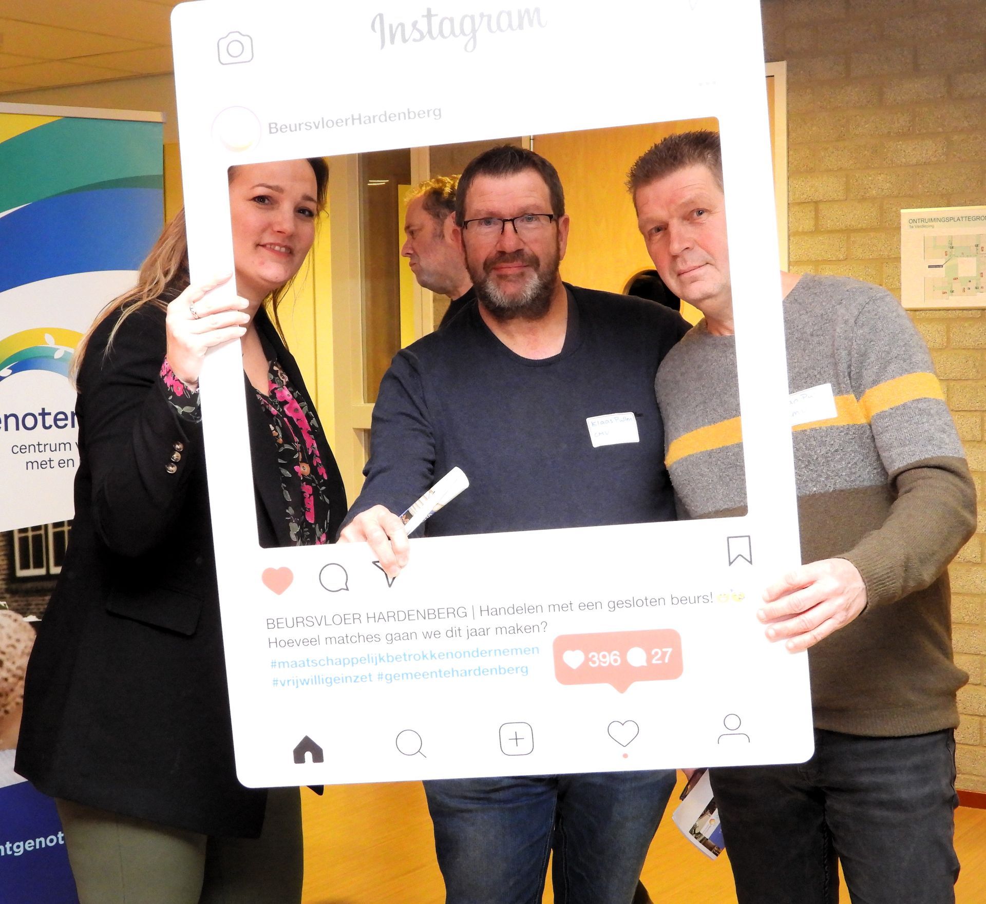 Drie mensen poseren voor een foto in een groot Instagram-frame.