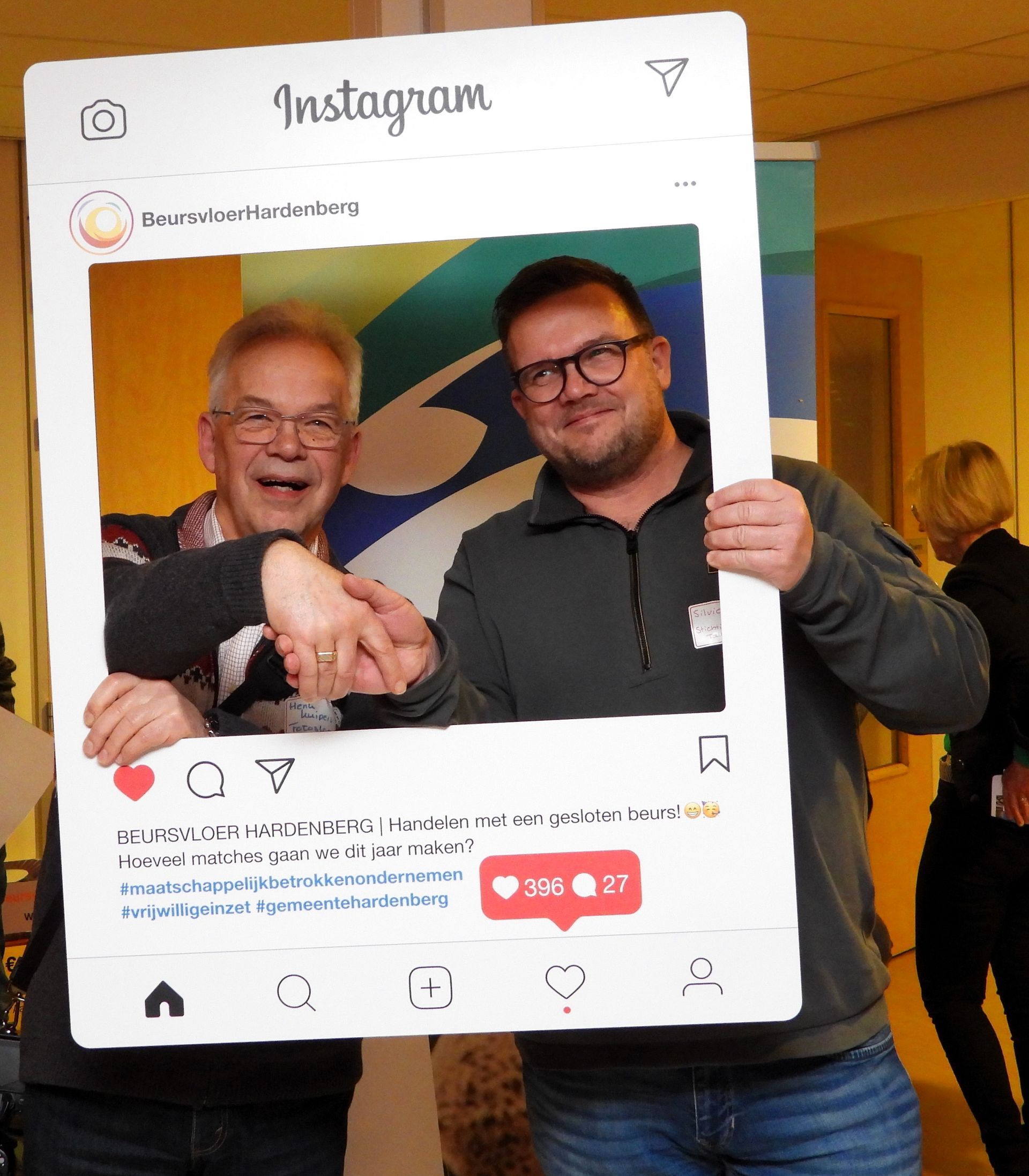 Twee mannen glimlachen en schudden elkaar de hand in een groot Instagram-frame.