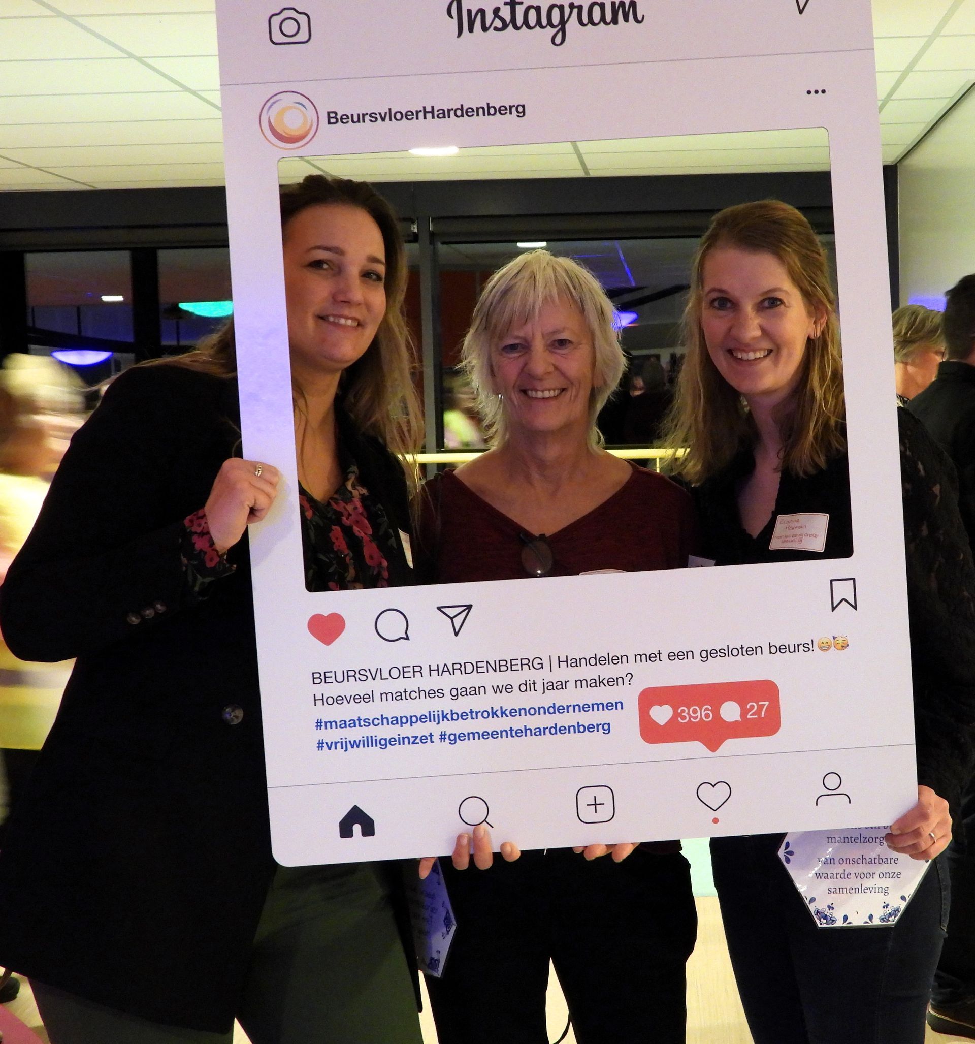 Drie vrouwen poseren achter een Instagram-frame tijdens een evenement.