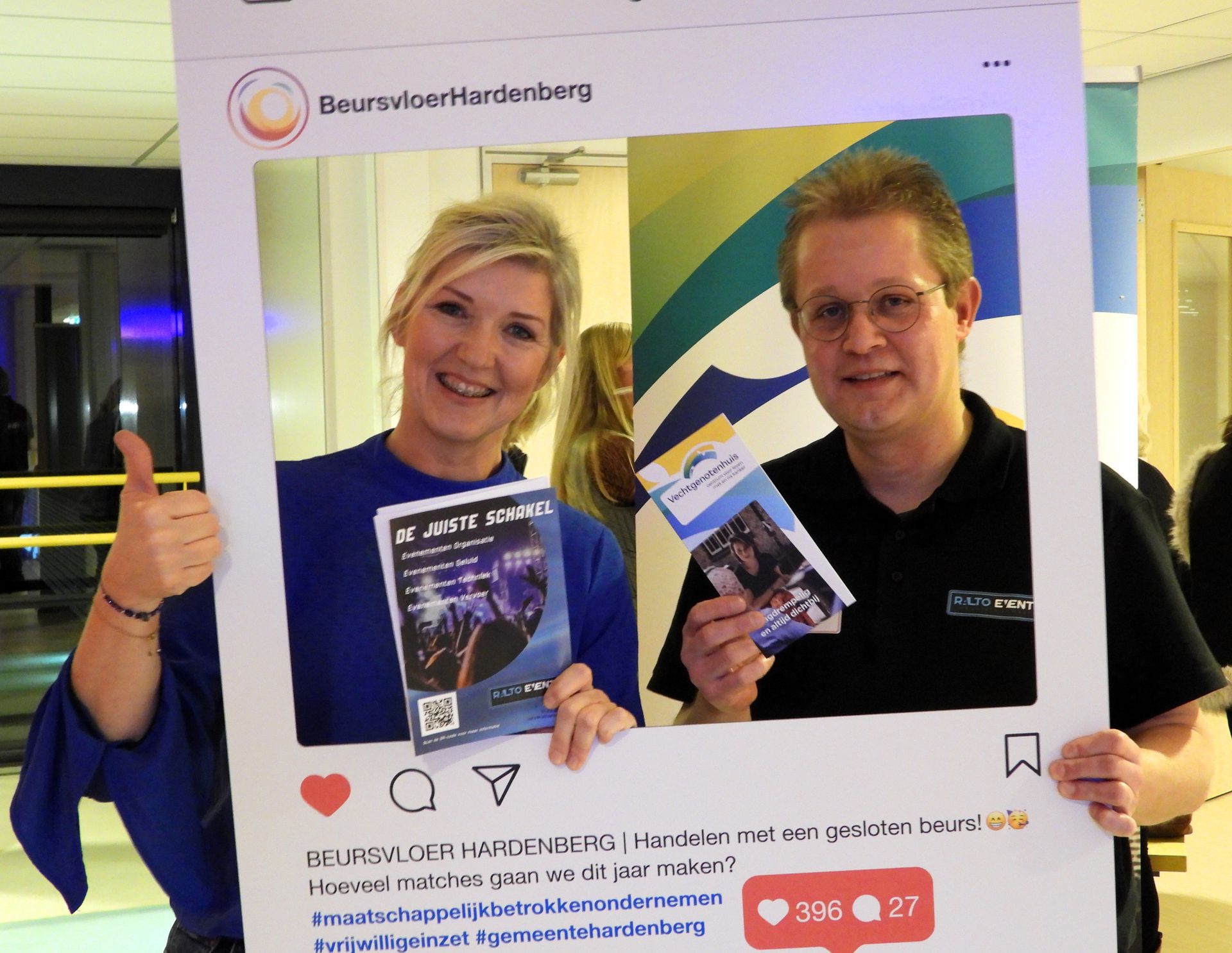 Twee mensen met marketingmateriaal in een Instagram-frame, lachend, binnen. De vrouw steekt haar duim omhoog.